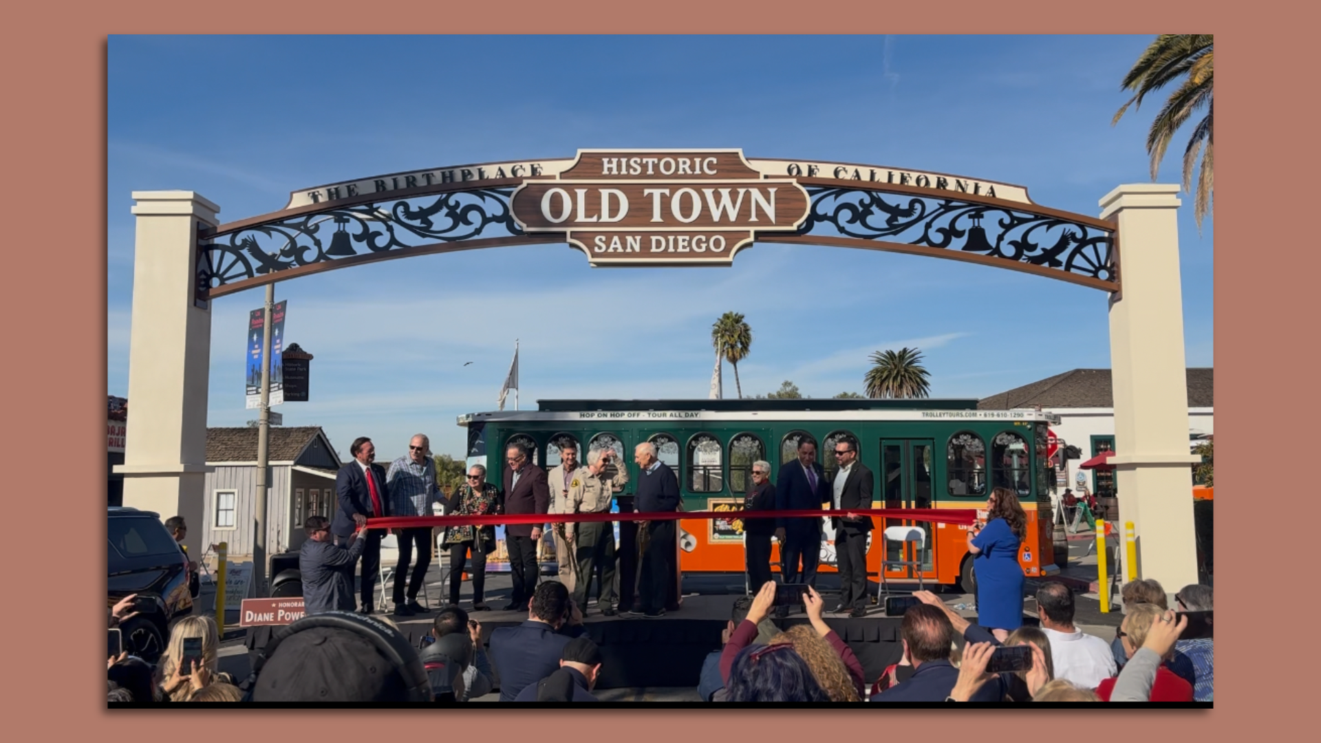 City leader stand on a stage under a new archway sign that says Old Town San Diego. 