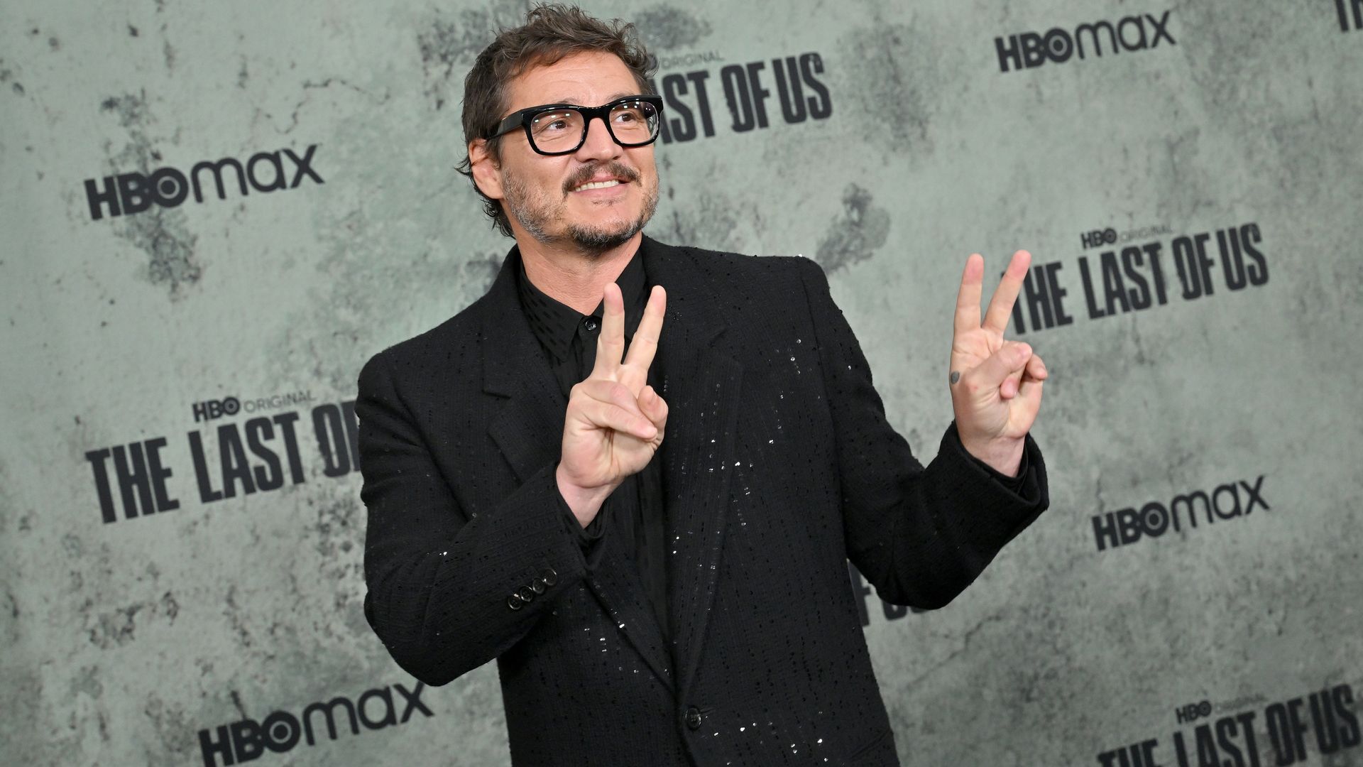 Pedro Pascal, giving two peace signs at a premiere. 