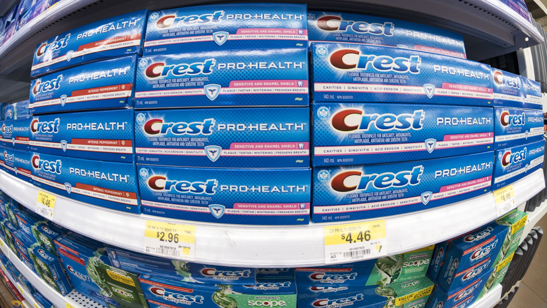A shelf filled with Crest toothpaste.