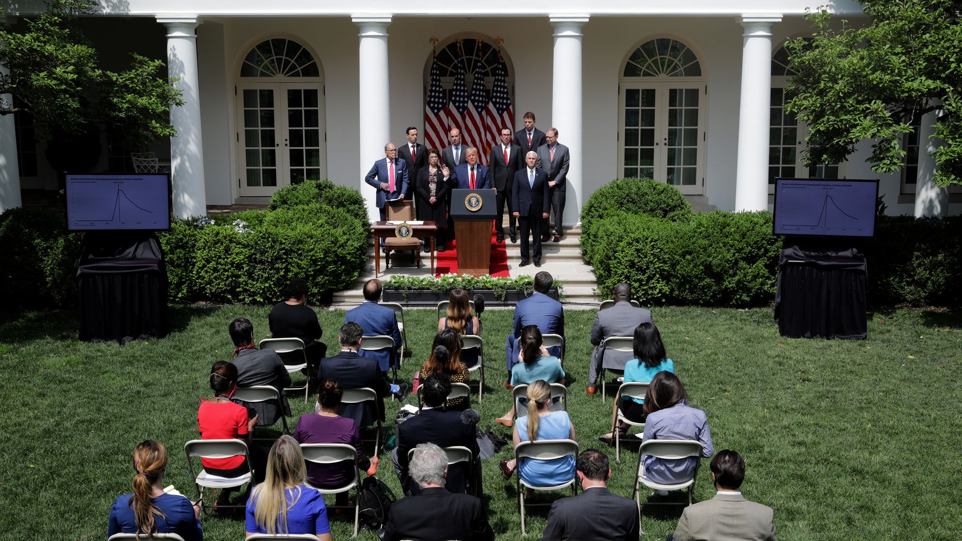 Several rows of people sit in the Rose Garden 