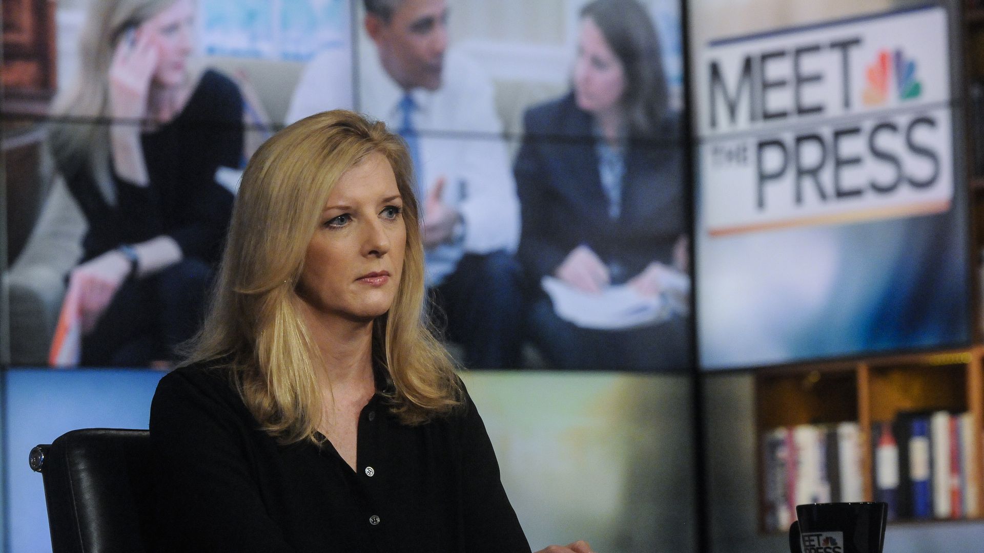 Blonde woman, Kathy Ruemmler, former White House counsel, in black seated in studio with "Meet the Press" logo and blurred panel discussion background, serious expression, with black coffee cup on desk.
