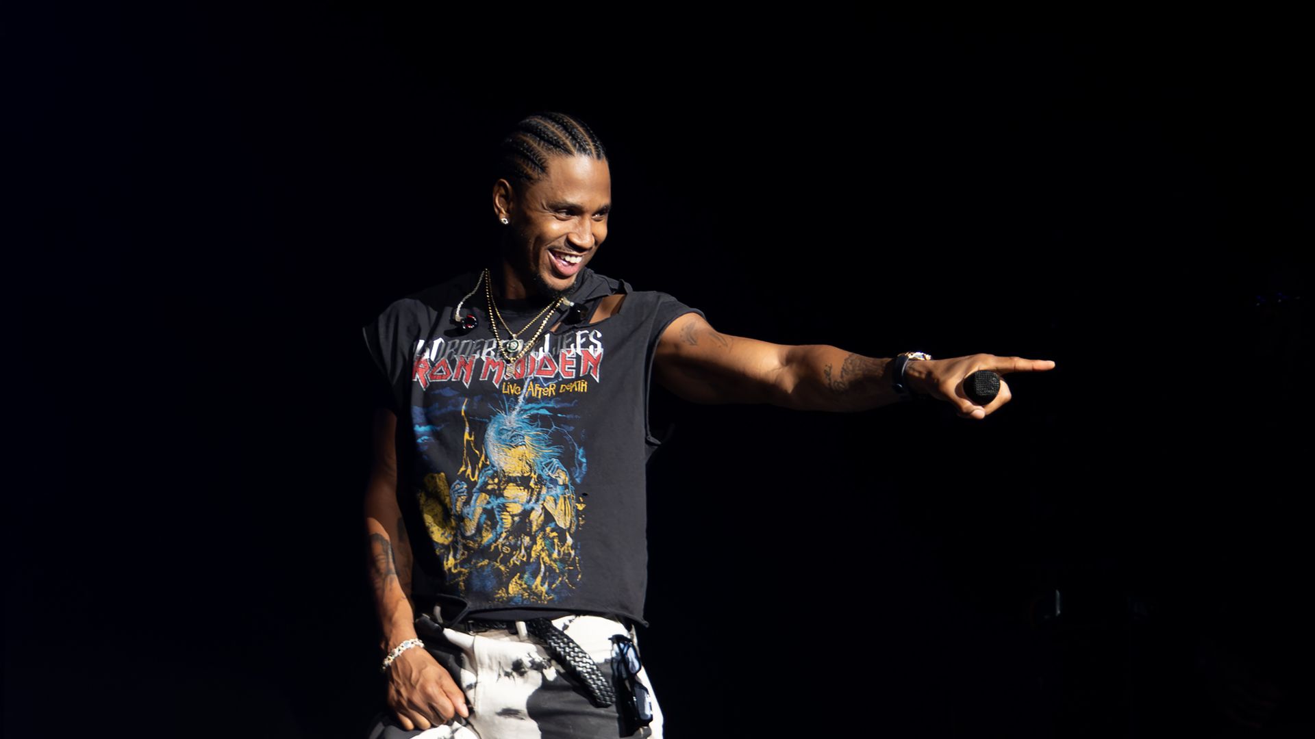 trey songz on stage pointing and smiling out at the audience