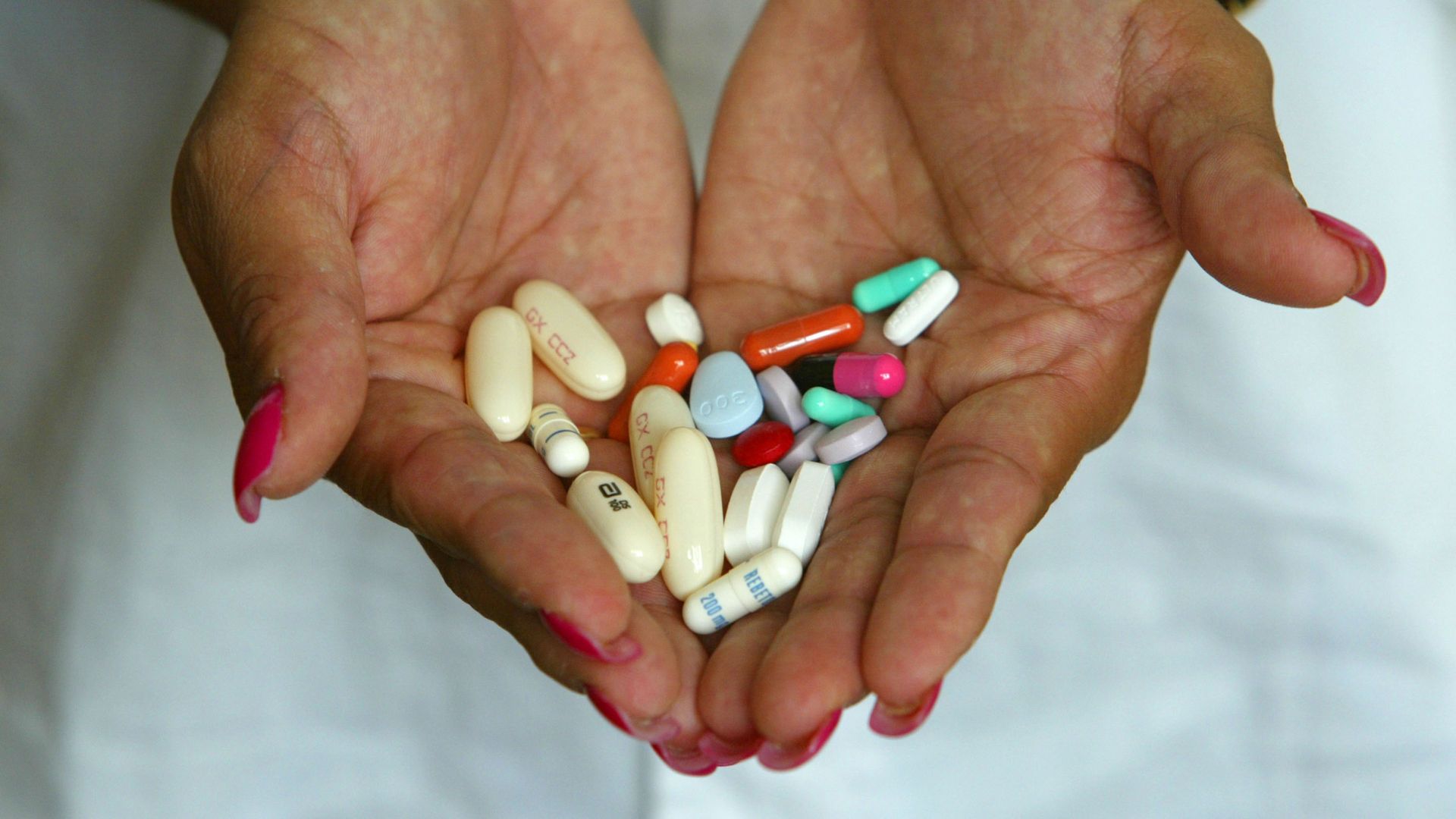 WOman holding cocktail of HIV pills