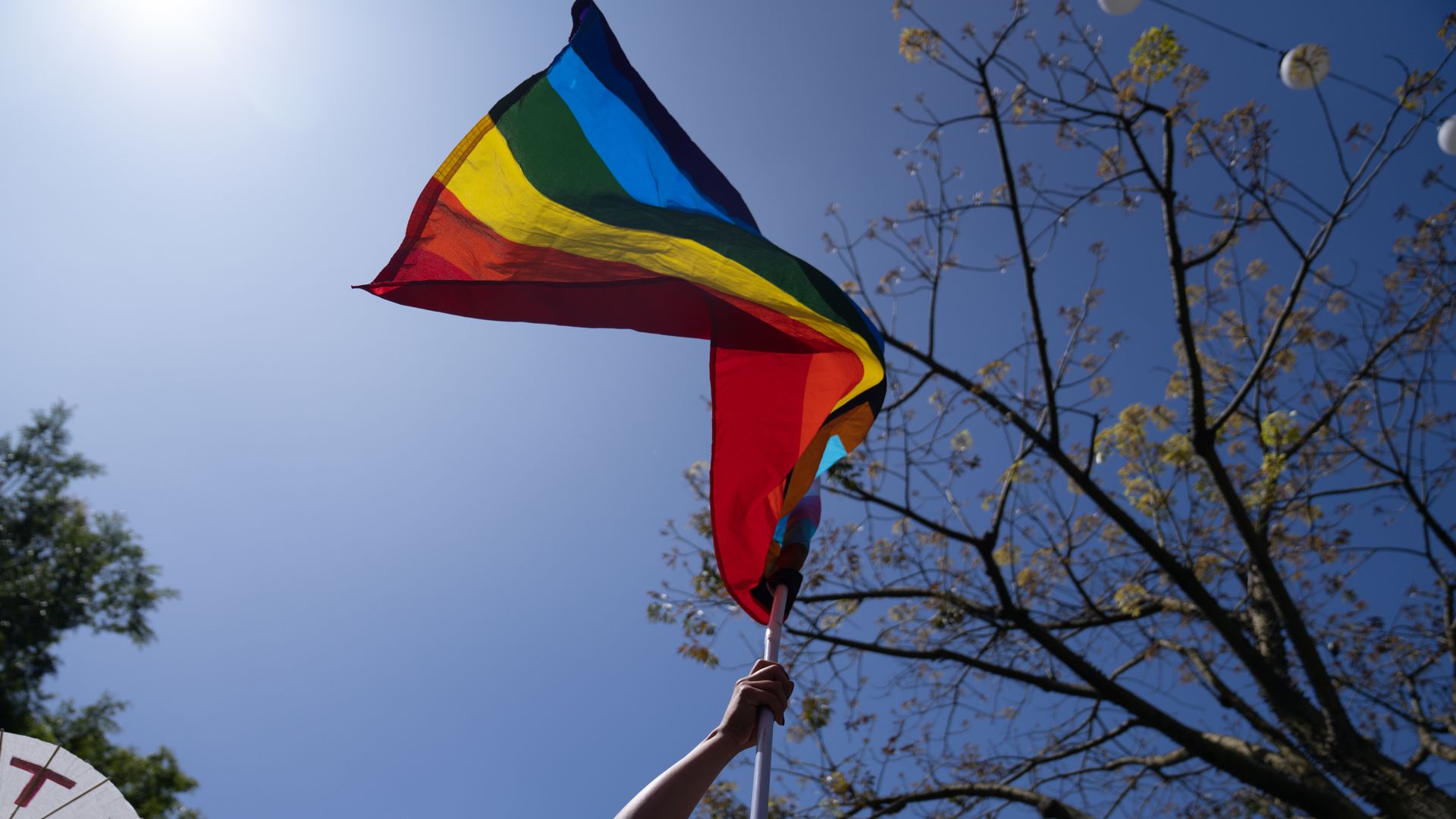 A demonstrator holds a rainbow pride flag during the Drag March LA protest in West Hollywood, California, US, on Sunday, April 9, 2023. 