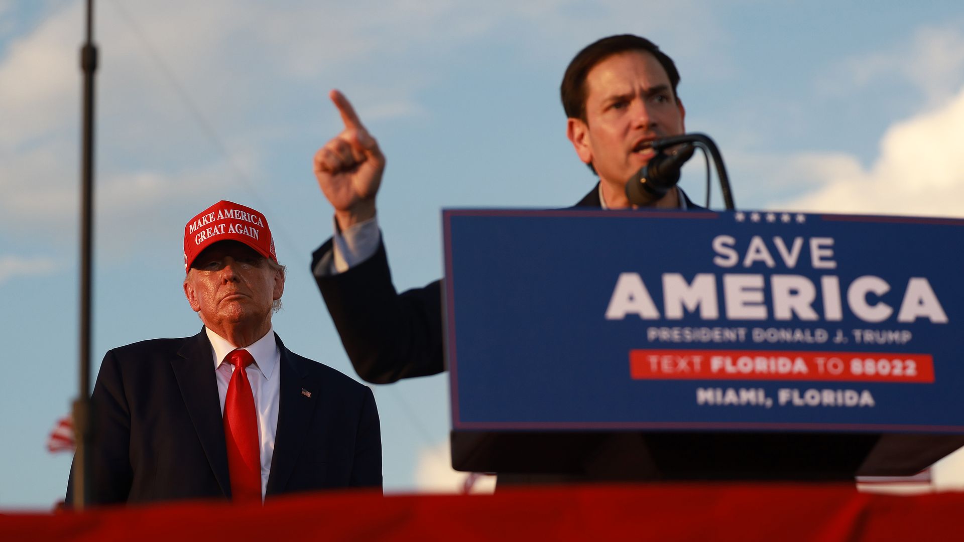 Former U.S. President Donald Trump listens as Sen. Marco Rubio speaks to a crowd of supporters