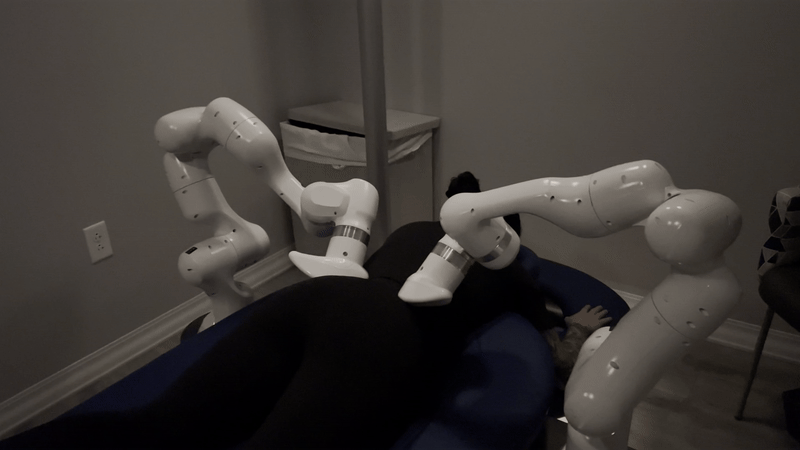 a gif of white robot arms going over the body of someone laying face down on a table