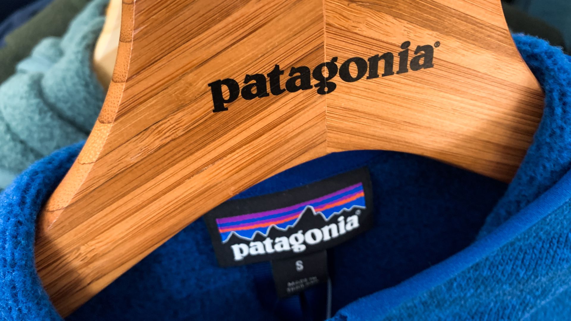 The Patagonia brand appears on a clothes hanger made out of wood.
