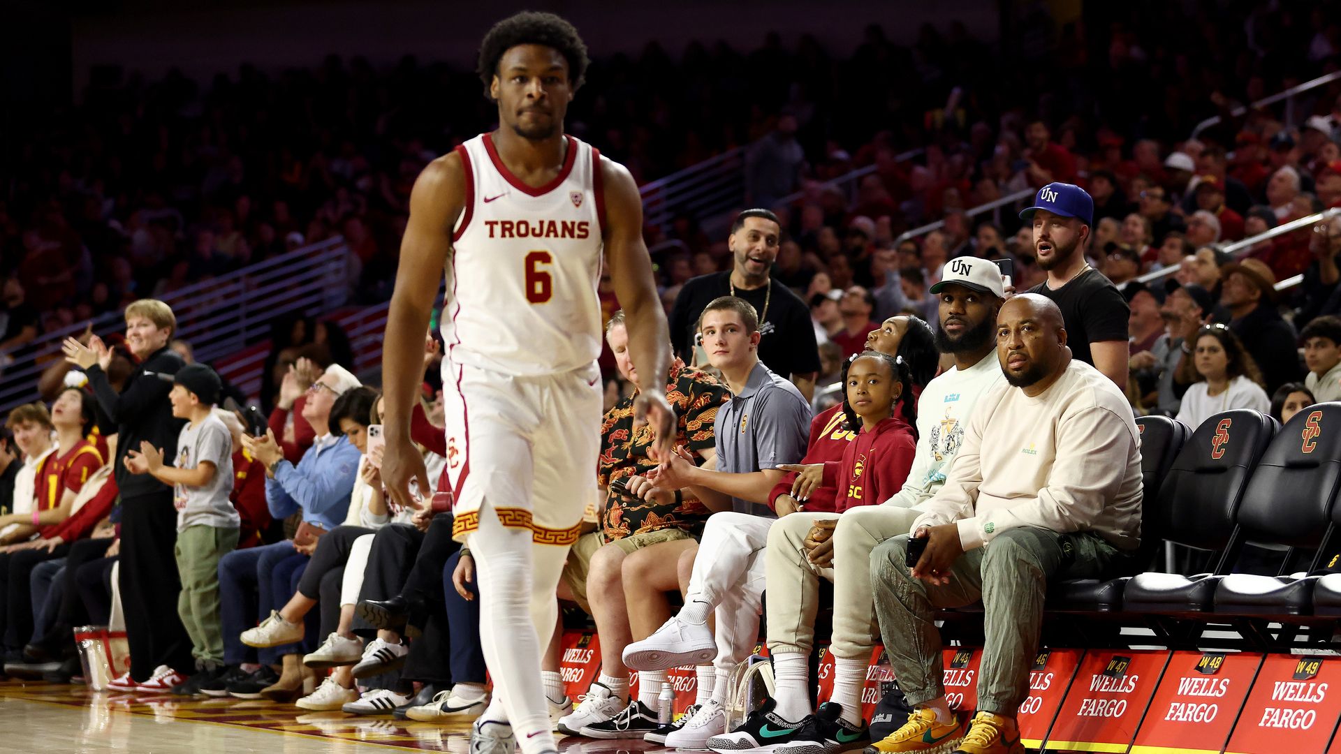 LeBron James (2nd R) looks on from the stands towards Bronny James #6 of the USC Trojans during the first half against the Long Beach State 49ers at Galen Center on December 10, 2023 in Los Angeles, California. 