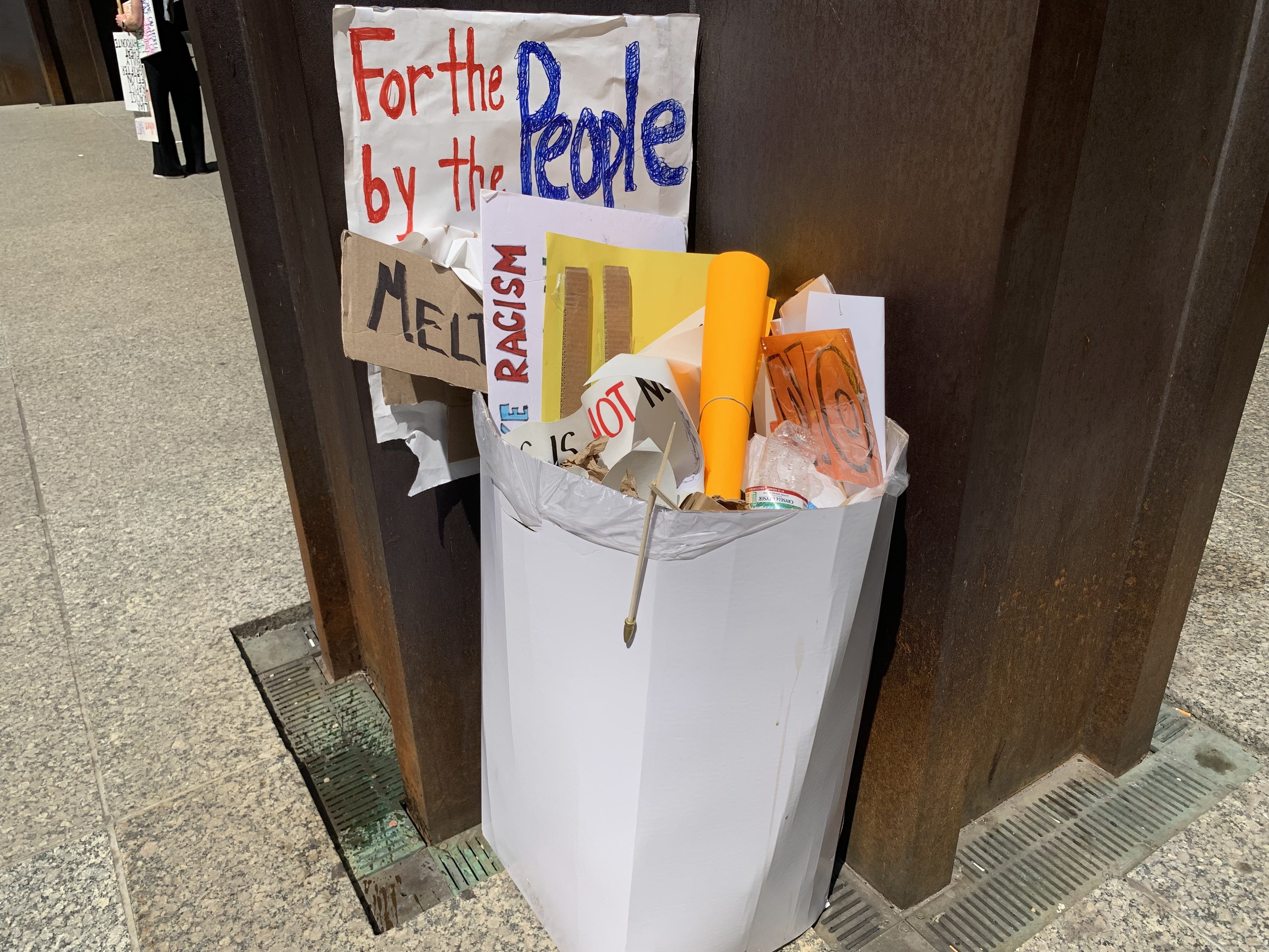  Protesters fill up a plaza with signs and march on a street. 
