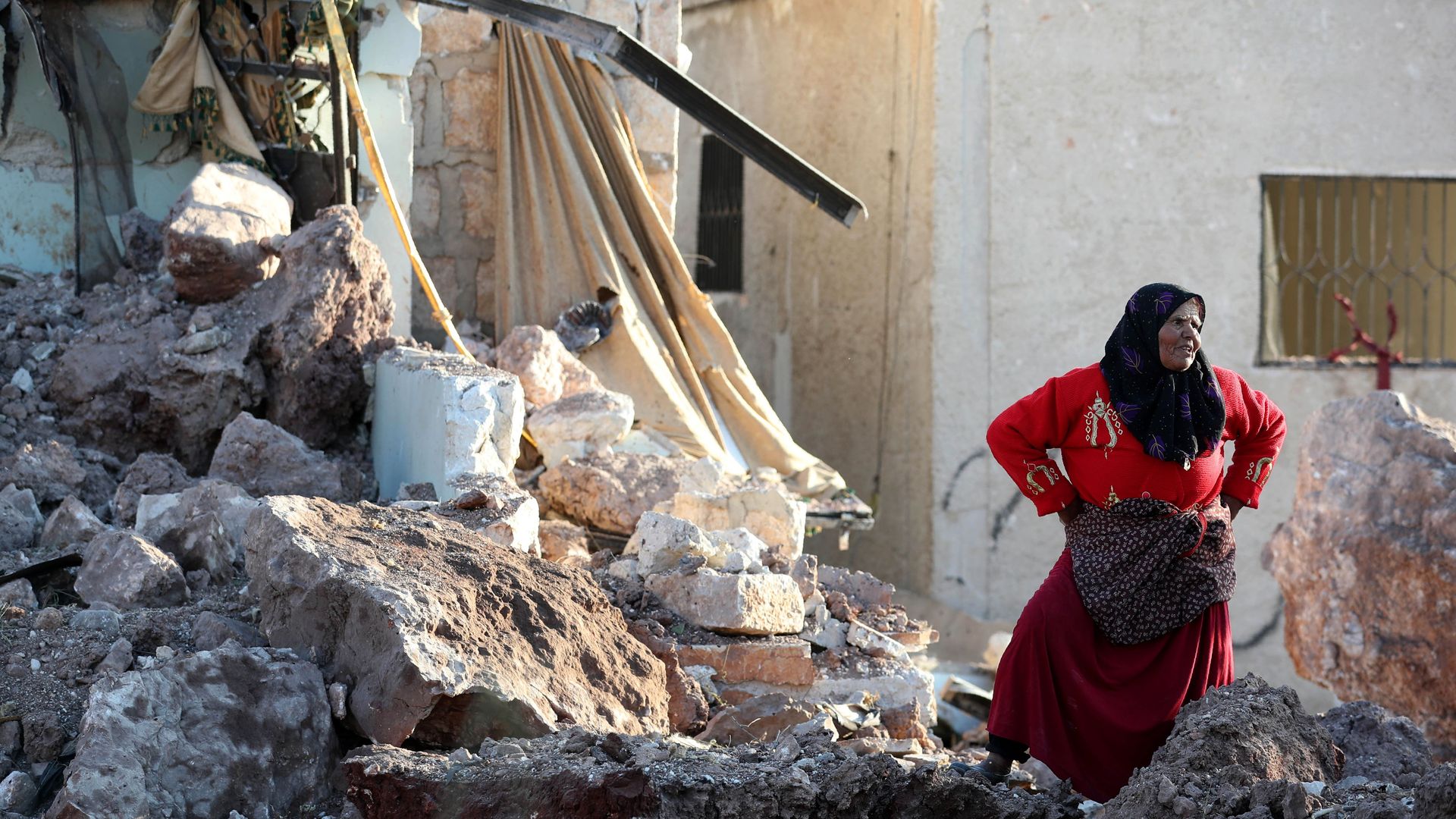 A woman standing in the rubbles following an attack in Idlib, Syria