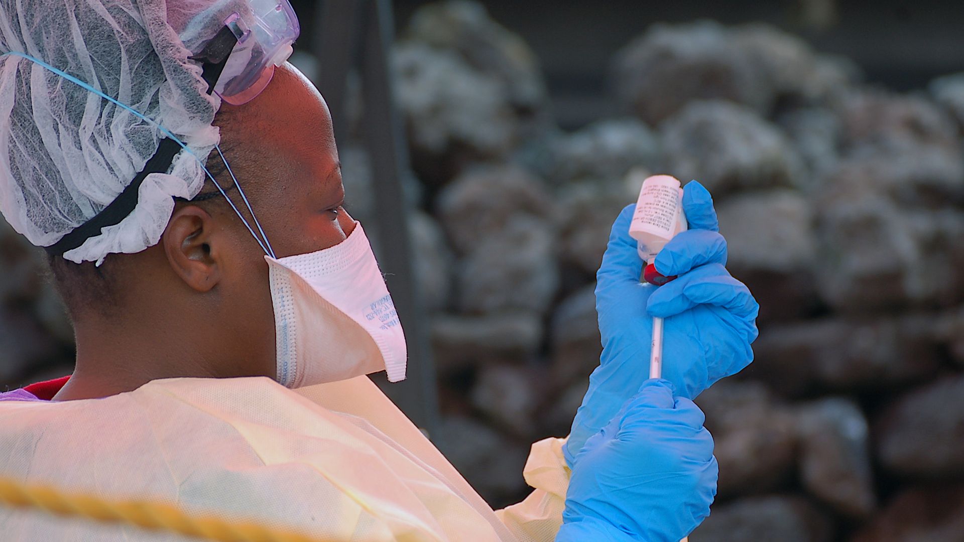 Photo of nurse drawing an Ebola vaccine out of the bottle into a needle