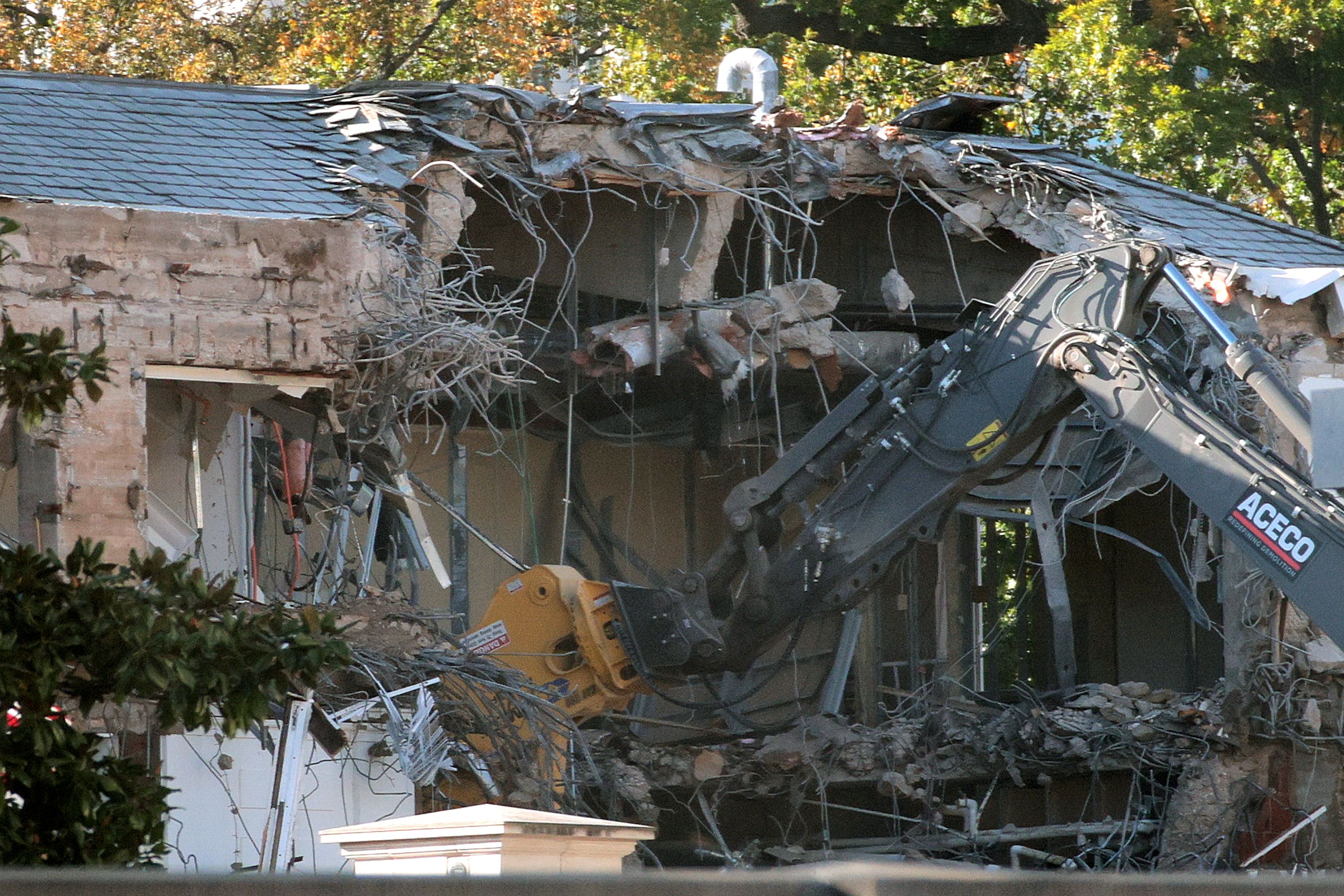 Workers demolish the facade of the East Wing of the White House yesterday.