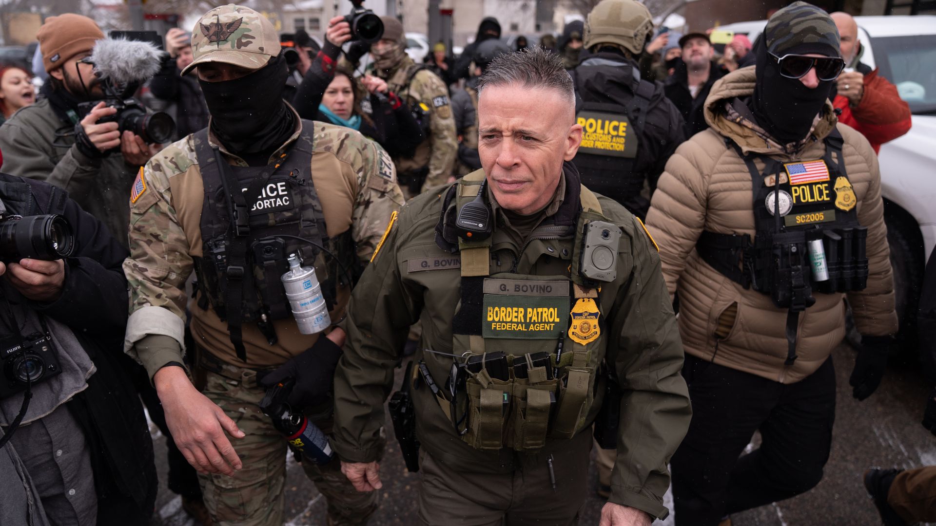U.S. Customs and Border Protection (CBP) Commissioner Gregory Bovino with his security team while a group of citizens opposed to the country's immigration policies protested him in Minnesota on January 21, 2026. (Photo by Lokman Vural Elibol/Anadolu via Getty Images)