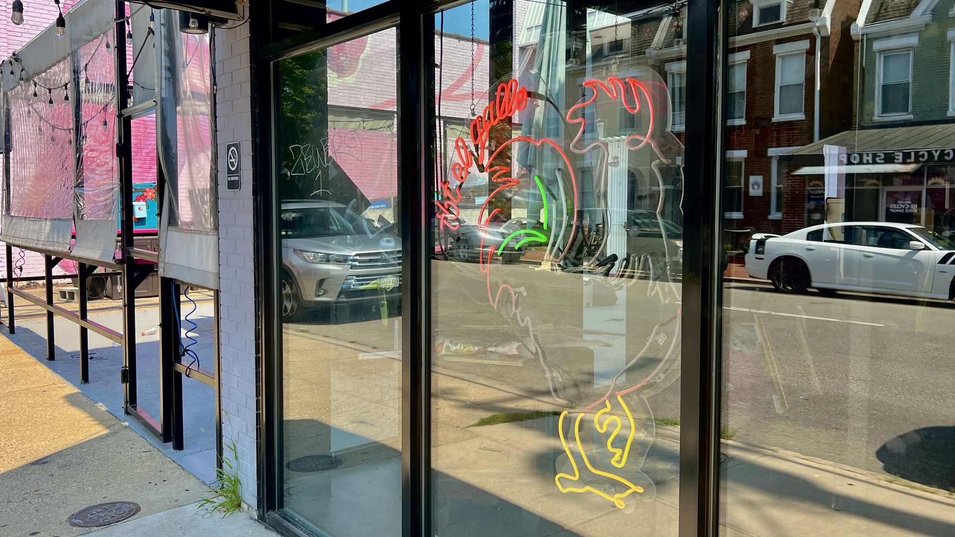 A neon rooster in a window 