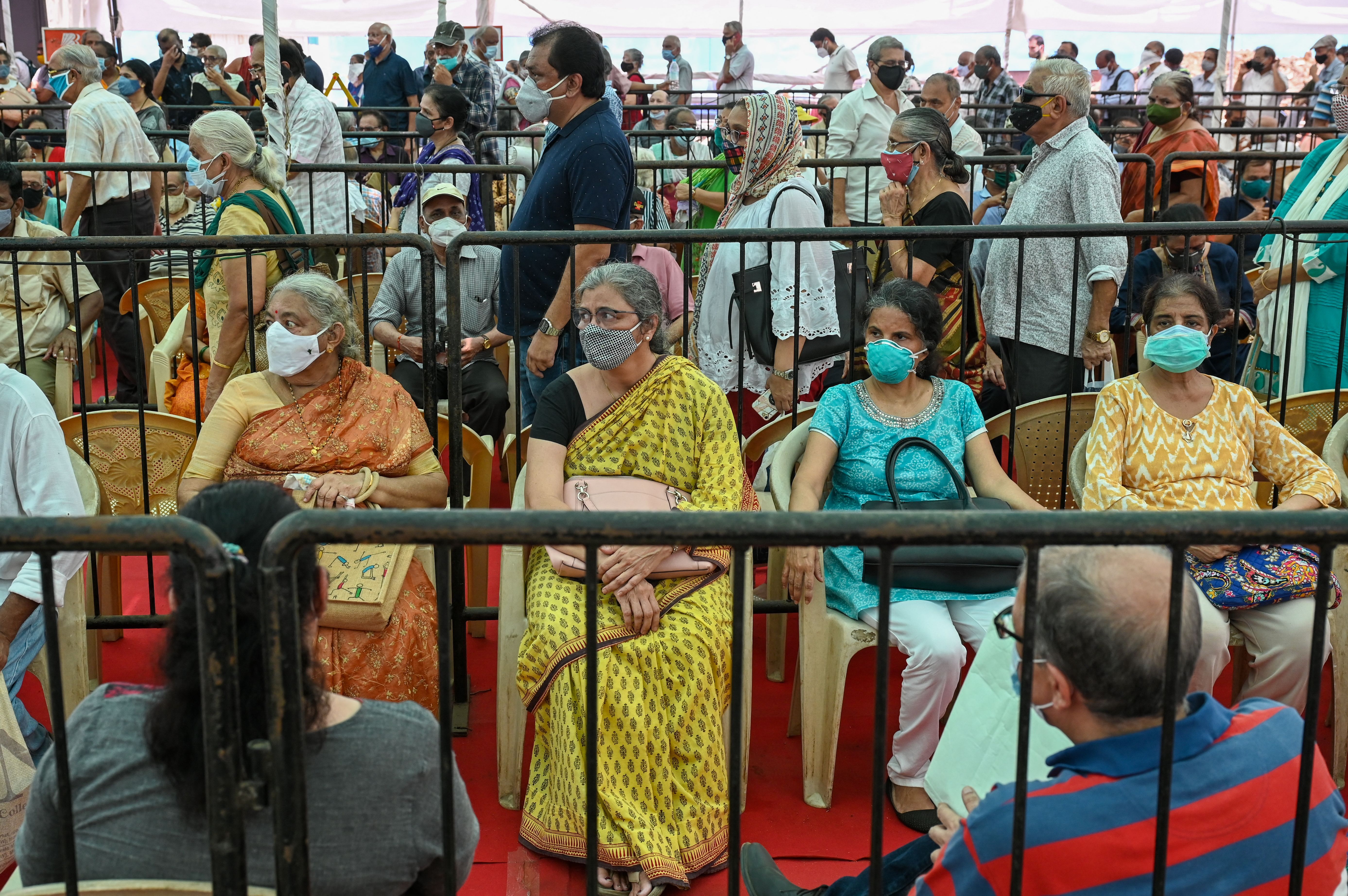 People queue up to receive a dose of a Covid-19 coronavirus vaccine at a vaccination centre in Mumbai on April 27