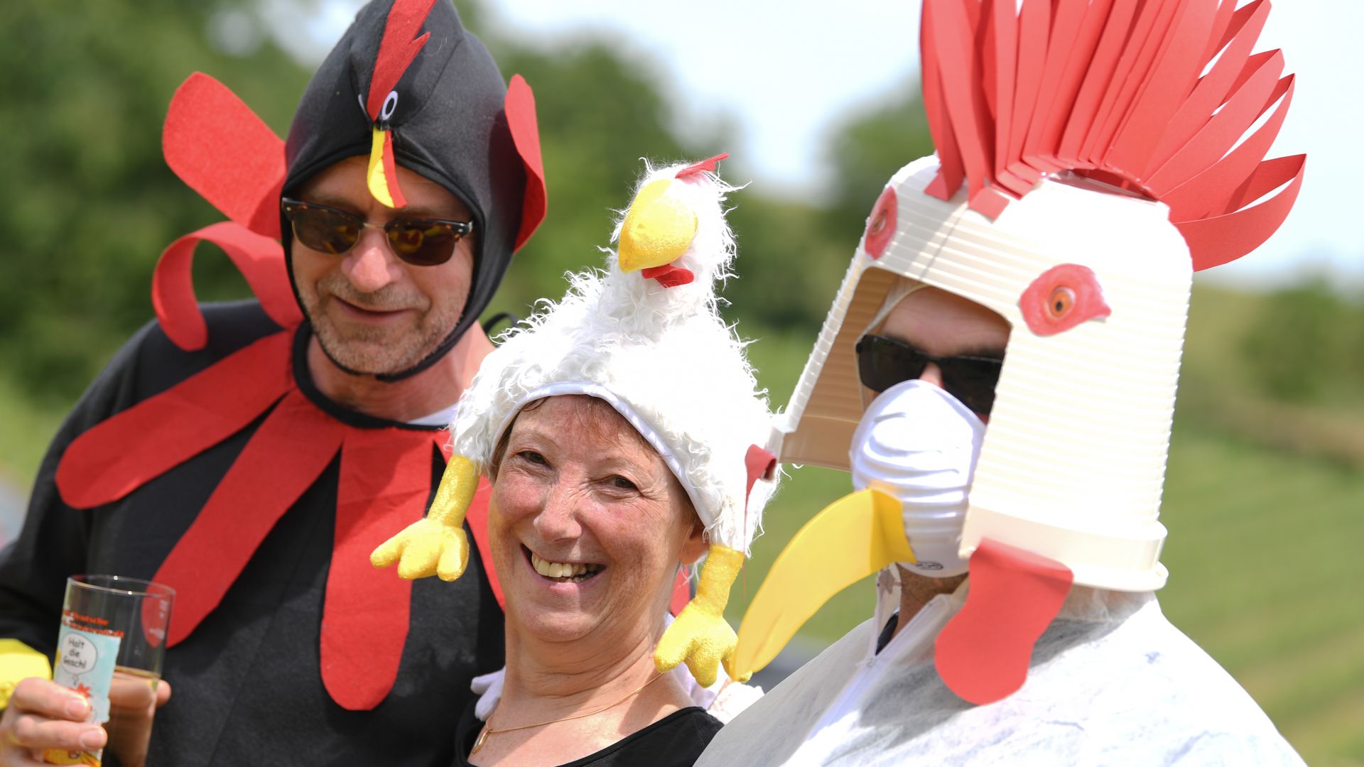 Men and woman dressed as roosters and drinking a beer