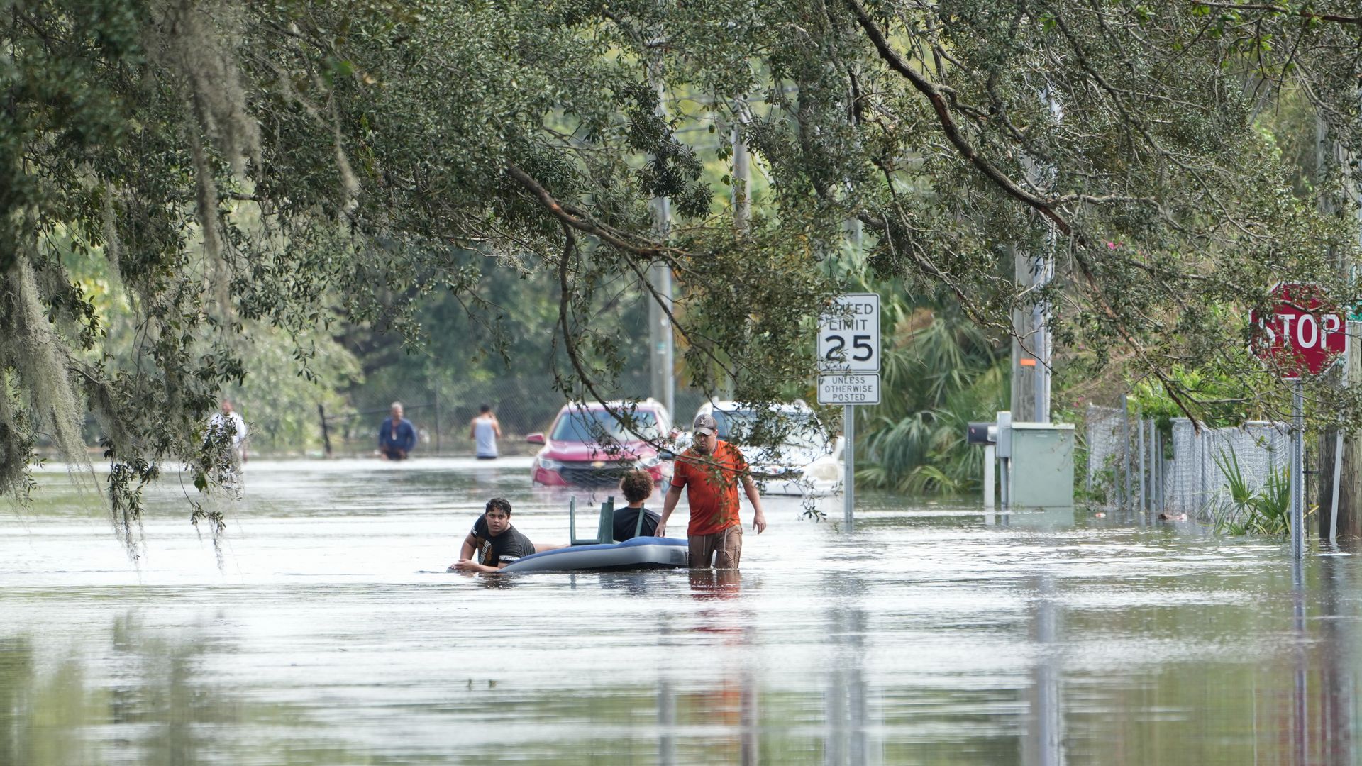 A resident tows an air mattress with people on it through flooded streets in Tampa due to Hurricane Milton .