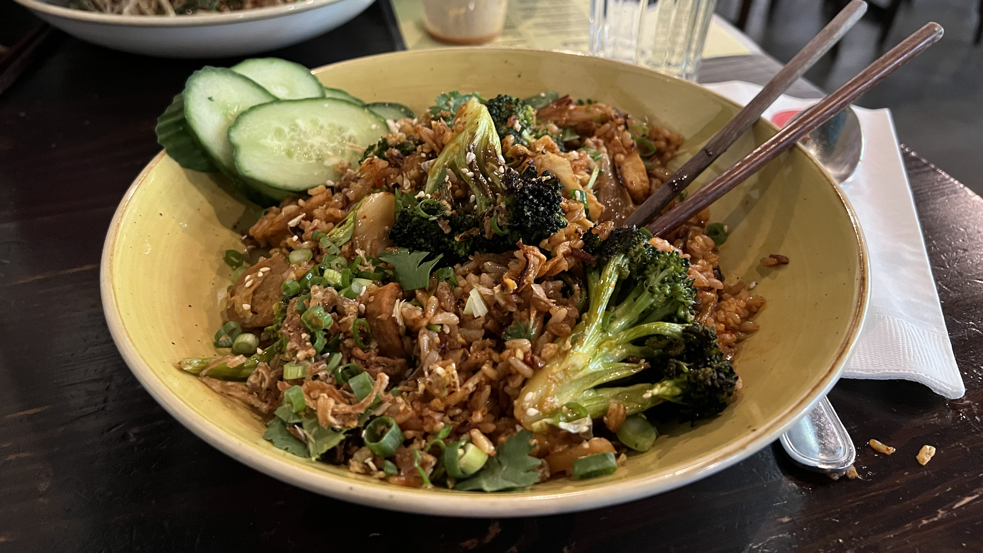 Photo of a noodle dish with broccoli in the foreground. 