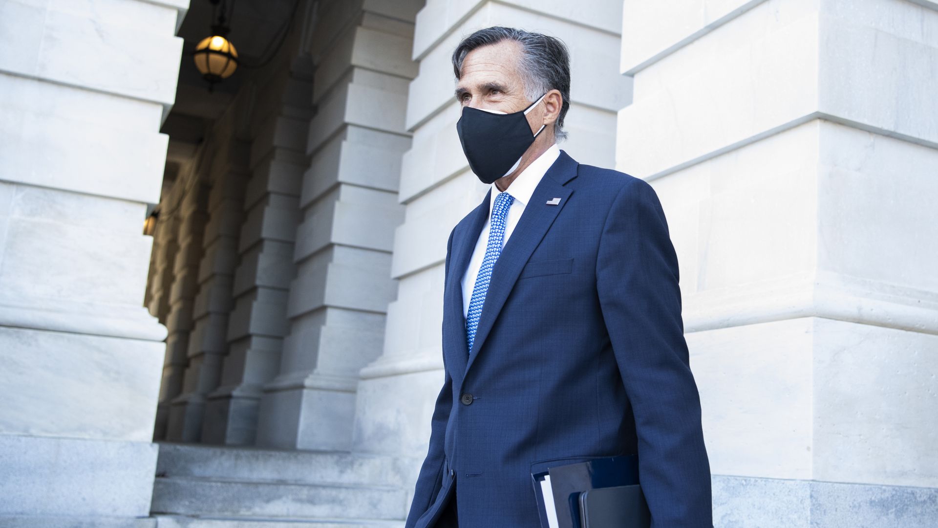 Photo of a masked Mitt Romney walking outside the Capitol 