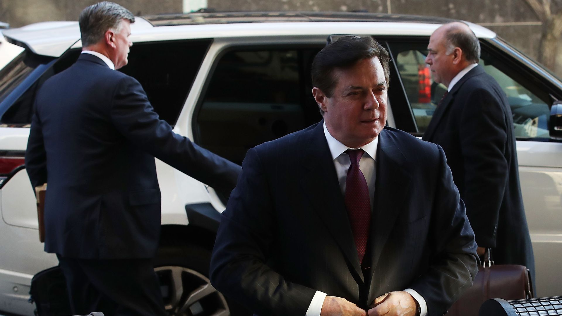 Paul Manafort buttons his suit.