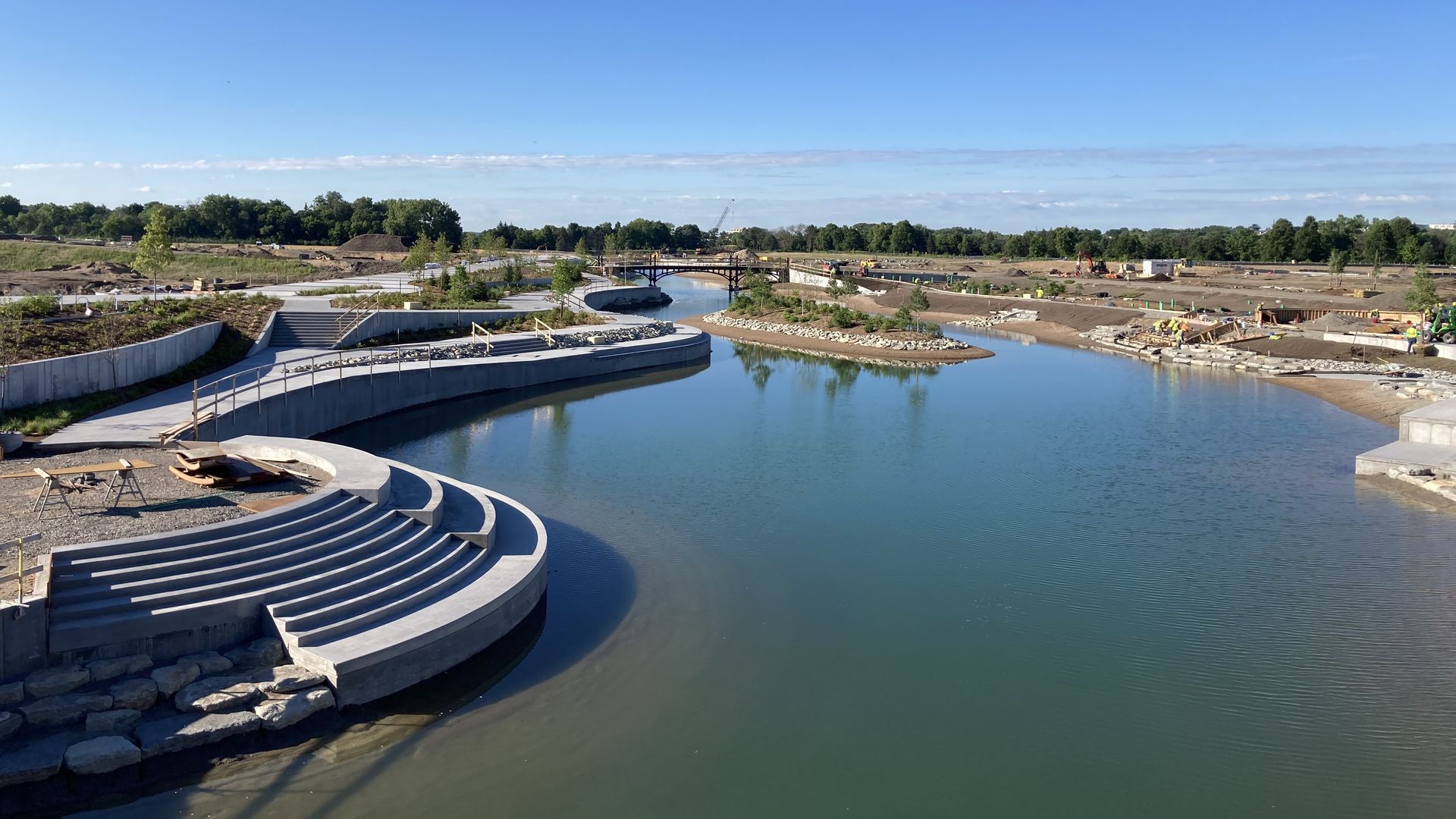 A new central water feature at St. Paul's Highland Bridge site with steps for enjoying the water and trails alongside.
