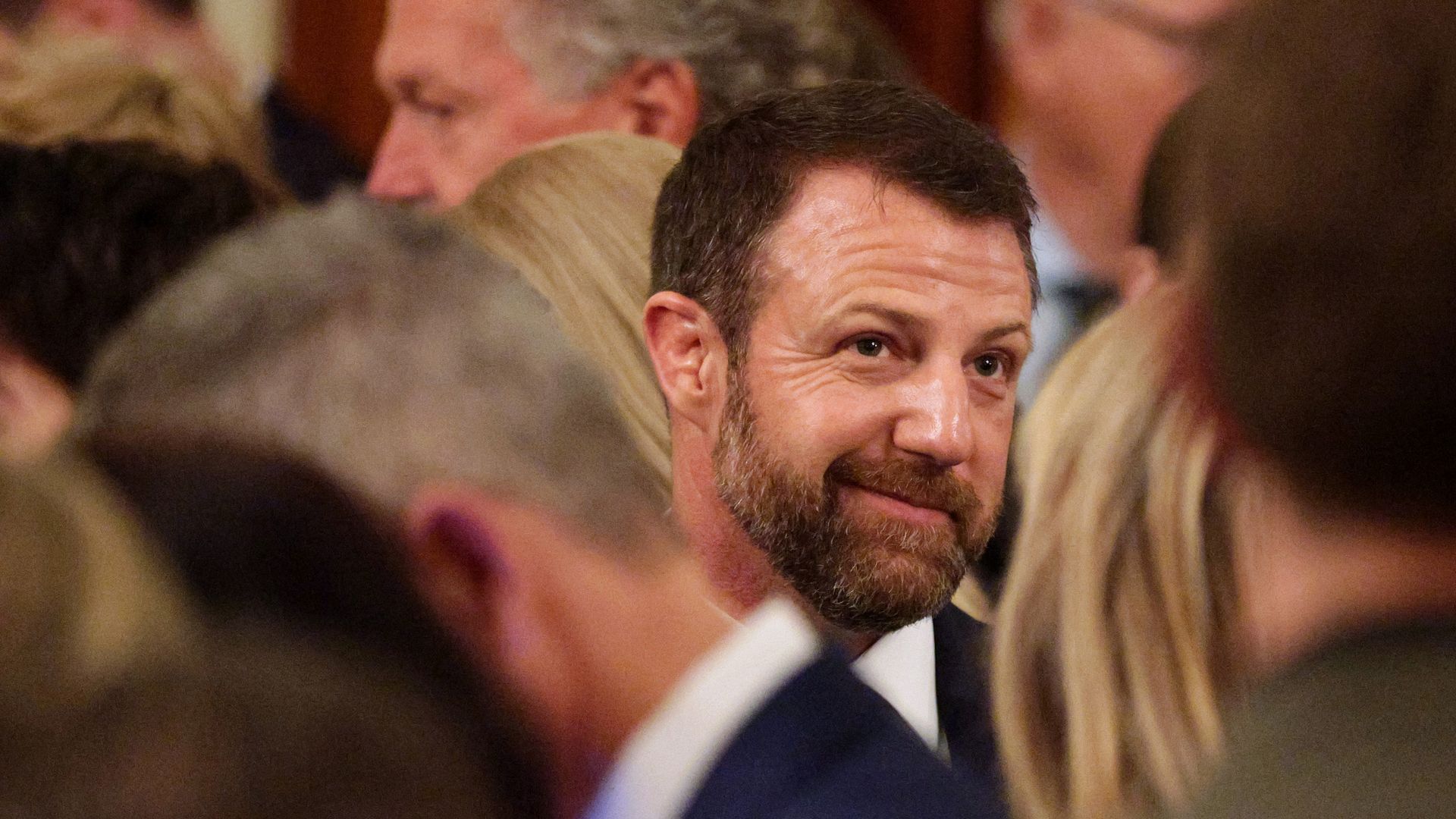 Sen. Markwayne Mullin's face is seen in the middle of several others.