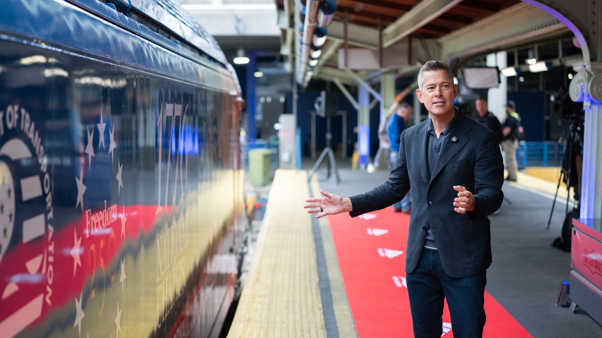 Sean Duffy stands in front of an Amtrak Acela train at Union Station decked out in Freedom 250 branding