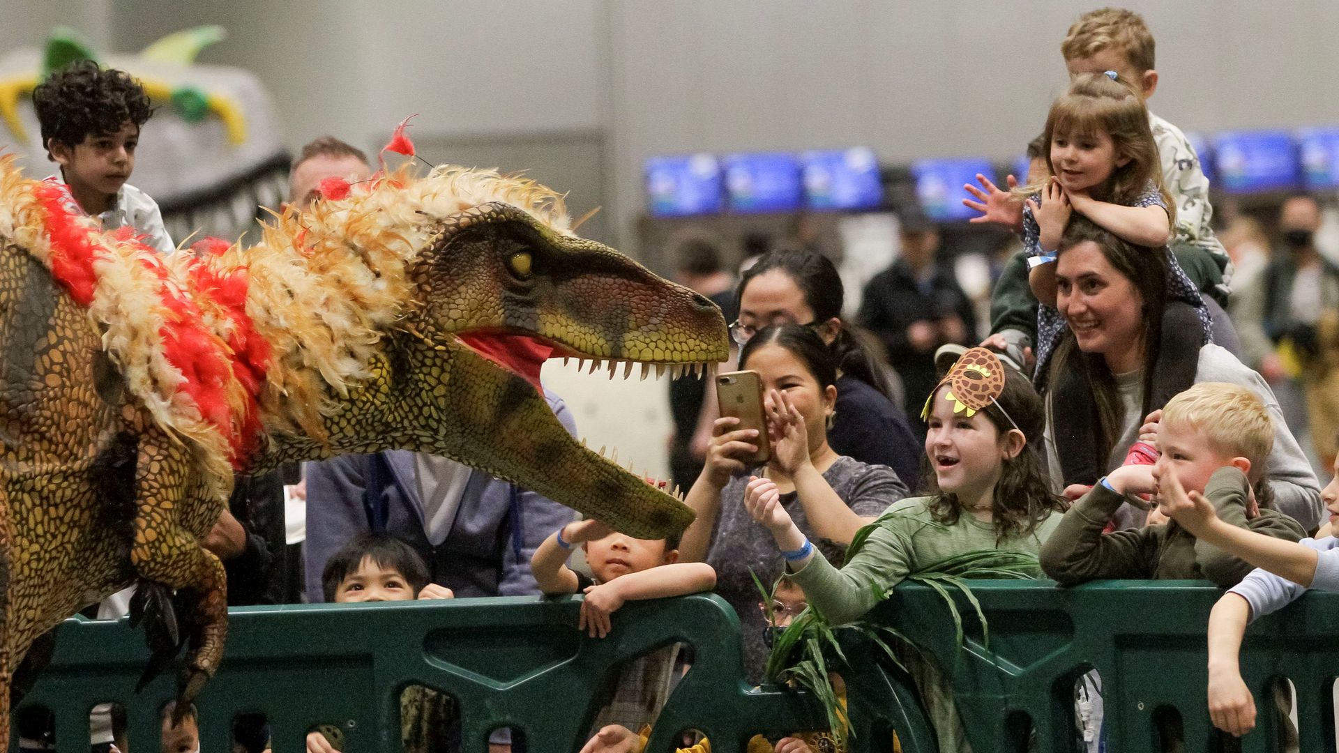 Kids view an interactive dinosaur exhibit.