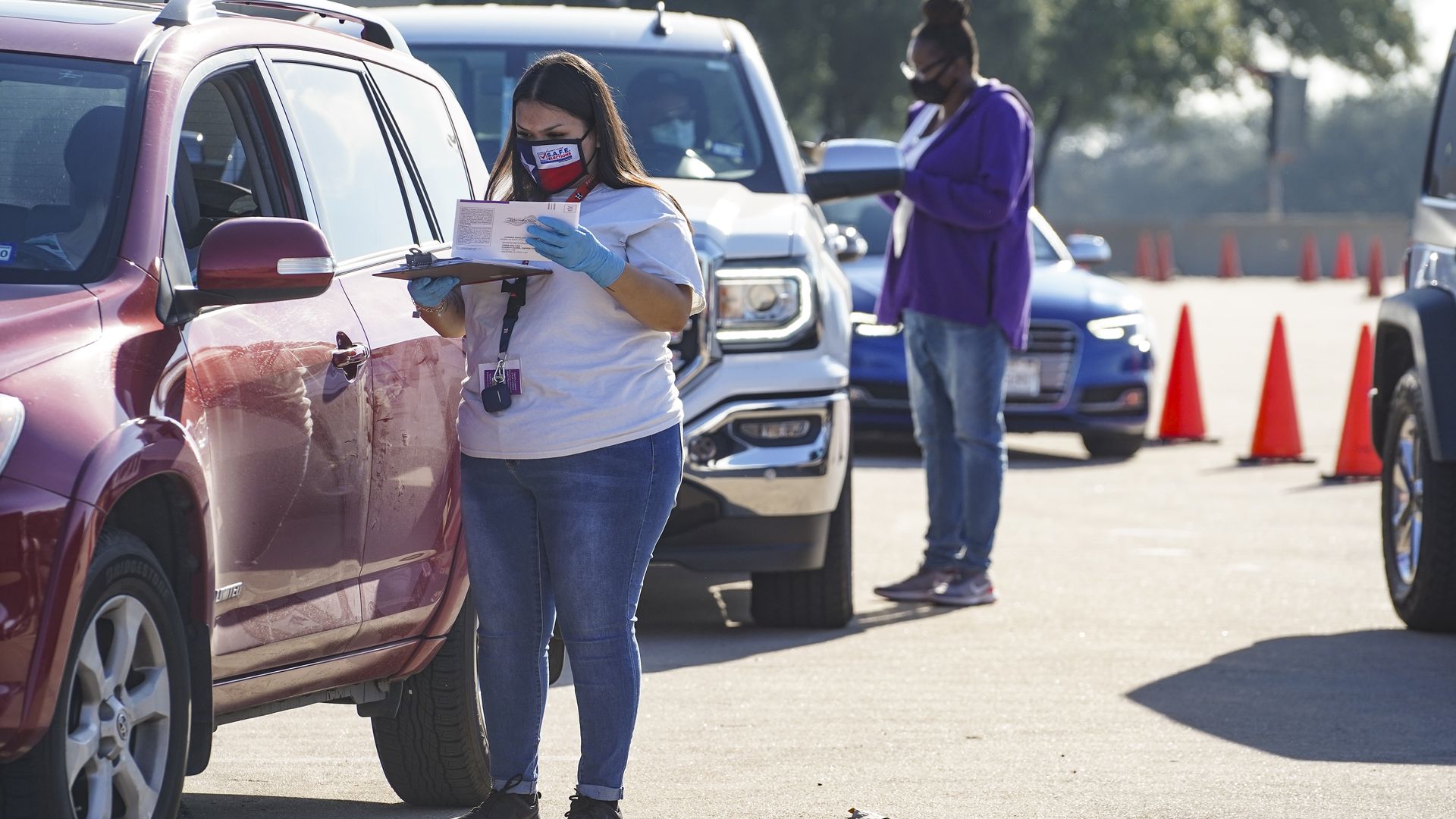 Election workers accept mail in ballot from voters in Houston on Oct. 7.