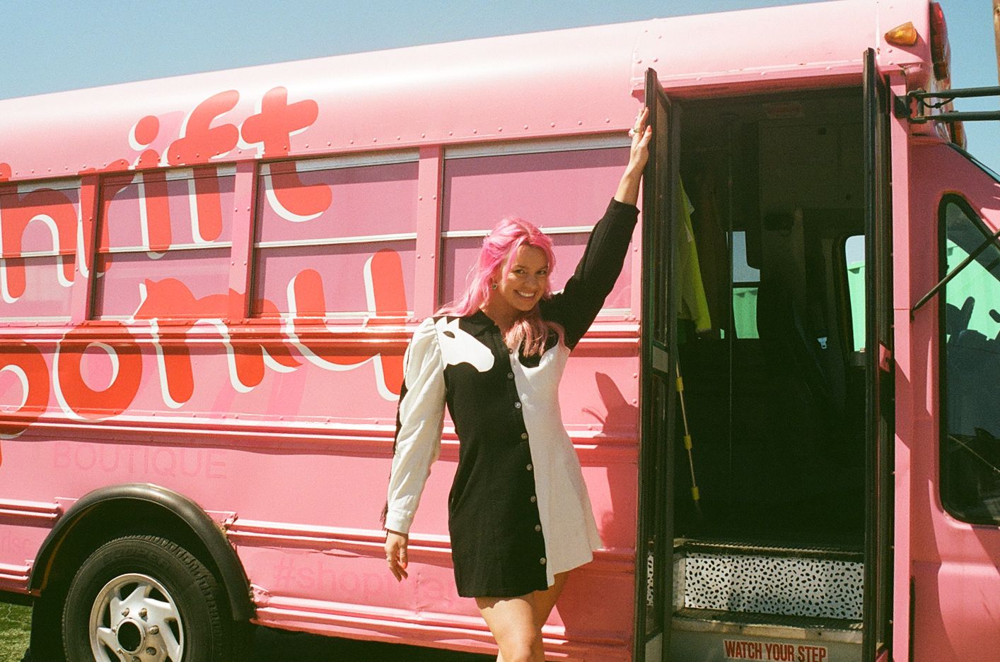 woman stands outside of school bus