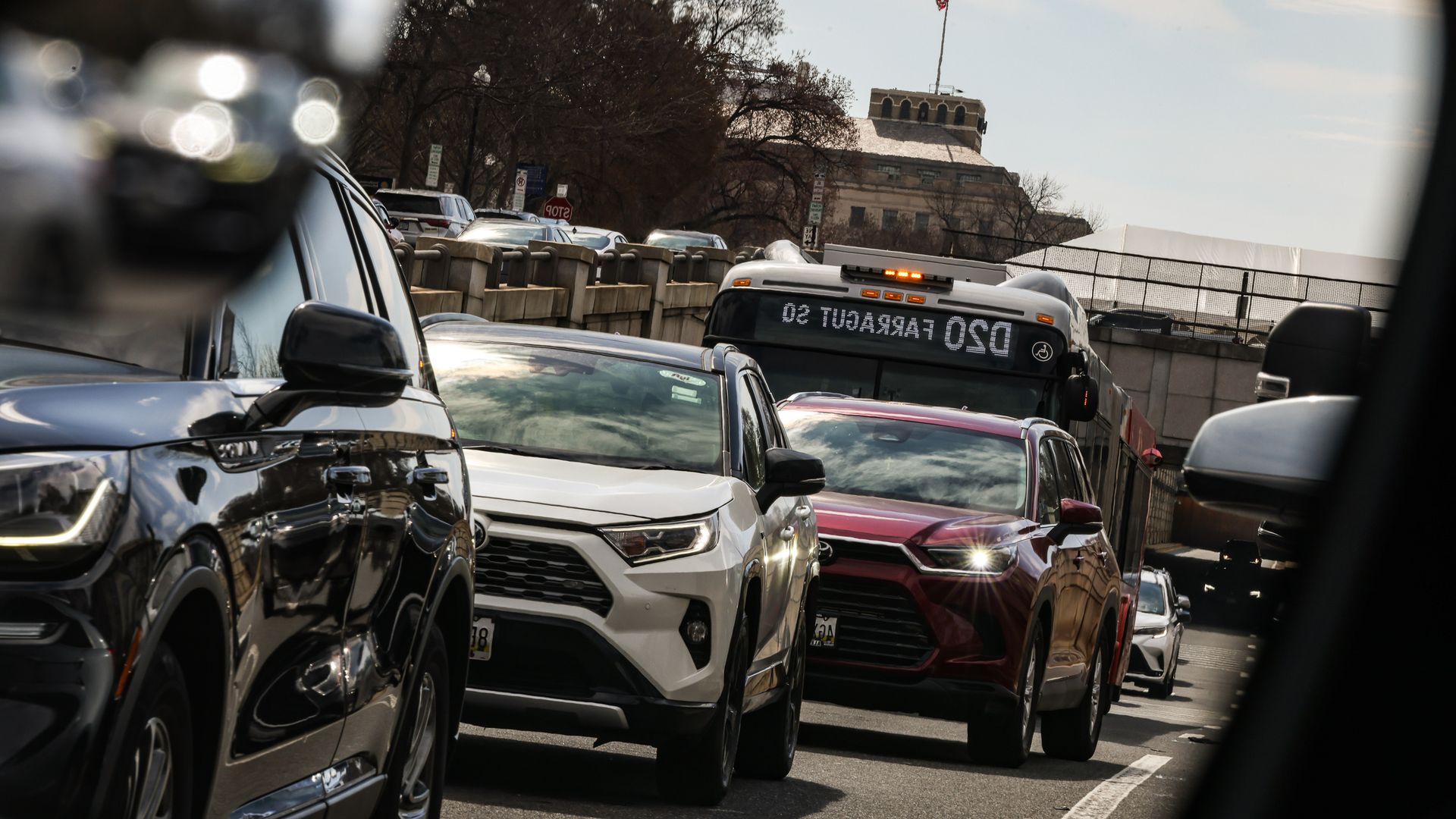 Cars in traffic and a bus on a roadway