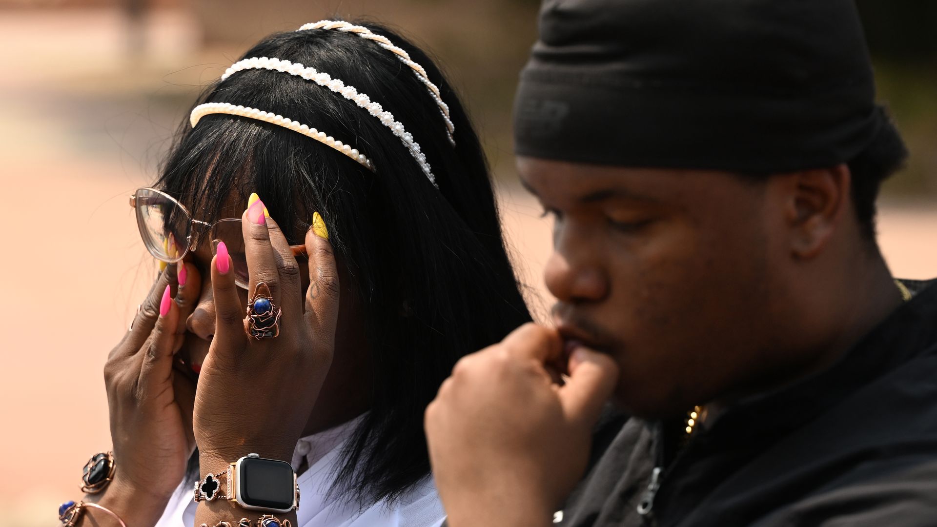 Community member Shontel Lewis, left, wipes away tears as she stands beside Rajon Belt-Stubblefield's son, Zion Murphy, during a press conference attended by family members and community supporters outside Arapahoe County District Court on Monday, Aug. 3, 2026, in Centennial