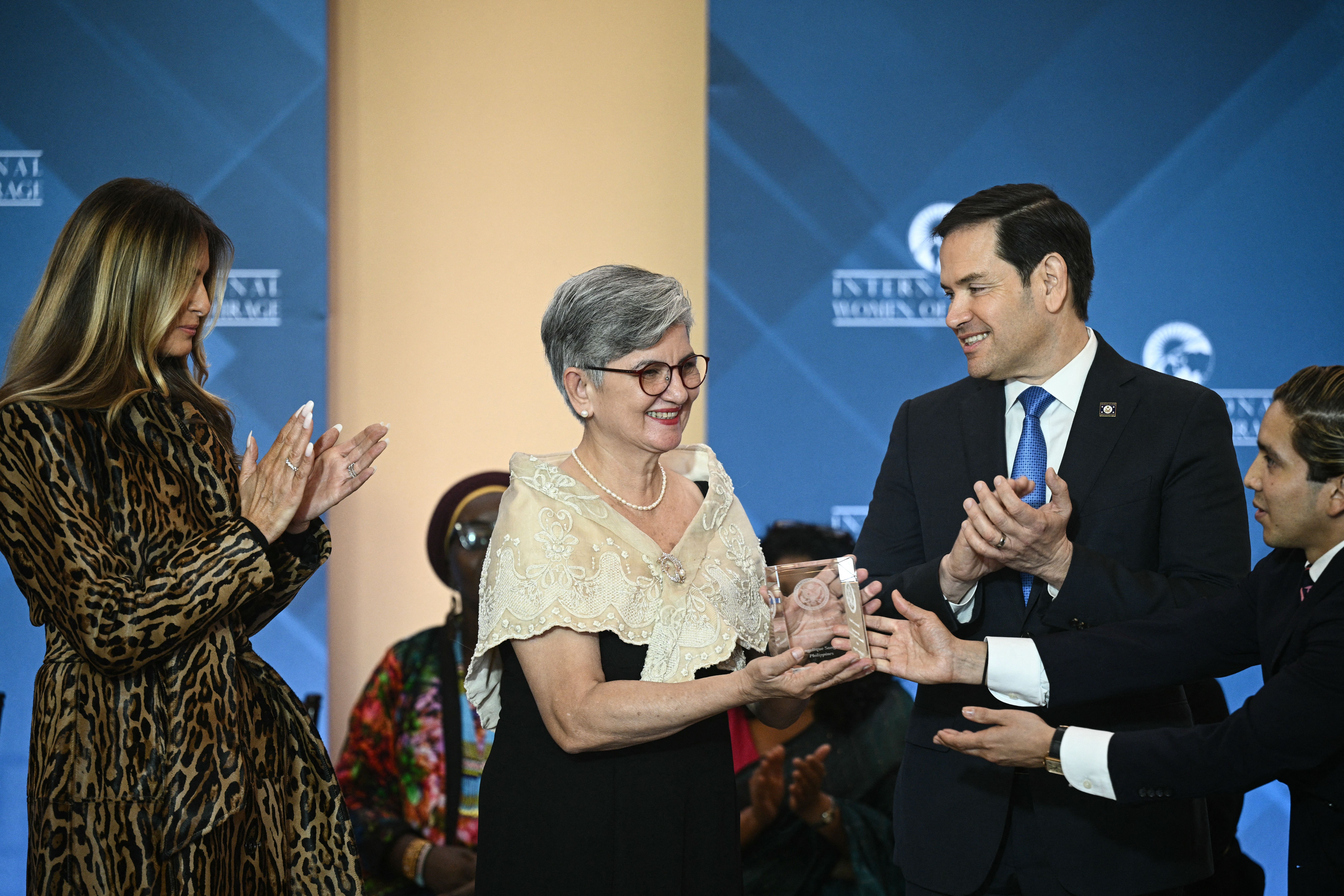 Angelique Songco (C), Protected Area Superintendent of Tubbataha Reefs Natural Park, is congratulated by US Secretary of State Marco Rubio (R) and First Lady Melania Trump (L) during the International Women of Courage Awards Ceremony at the State Department in Washington, DC, on April 1, 2025. 