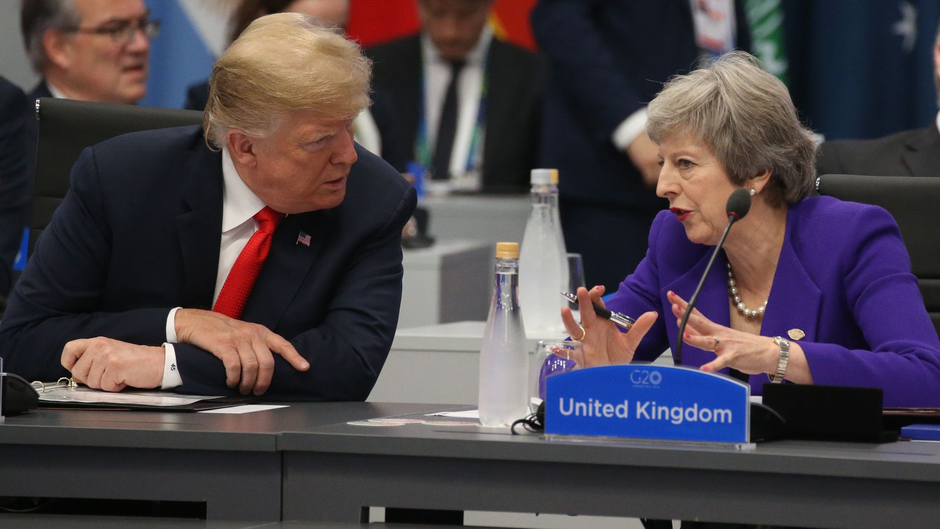 Donald Trump and Theresa May seated next to each other at a conference table