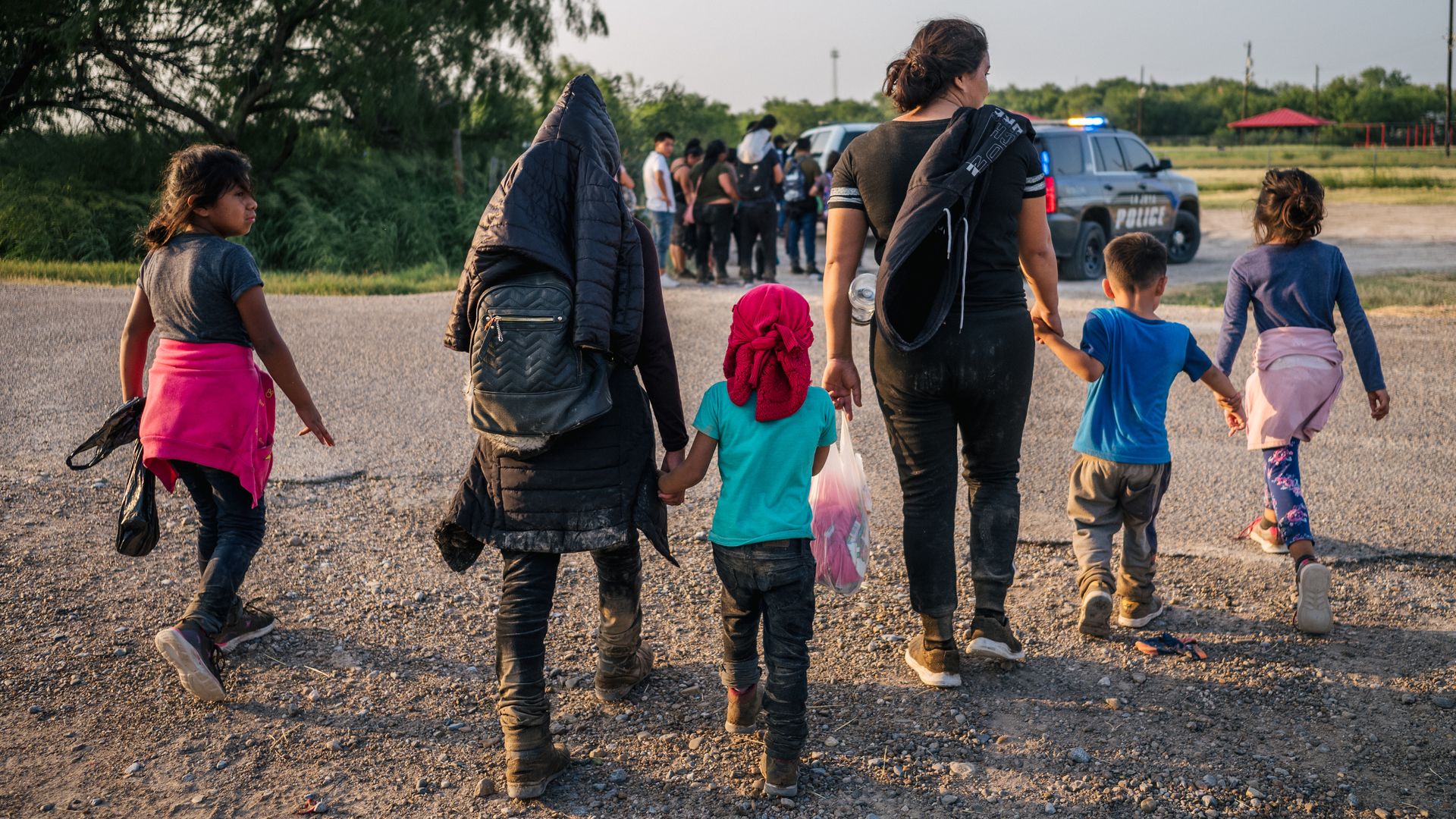 Migrants are seen heading toward law enforcement officials after crossing the U.S.-Mexico border.