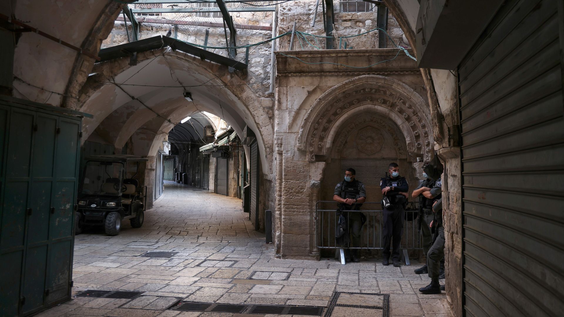 Photo of a group of masked police officers standing in a corner of an old Jerusalem street
