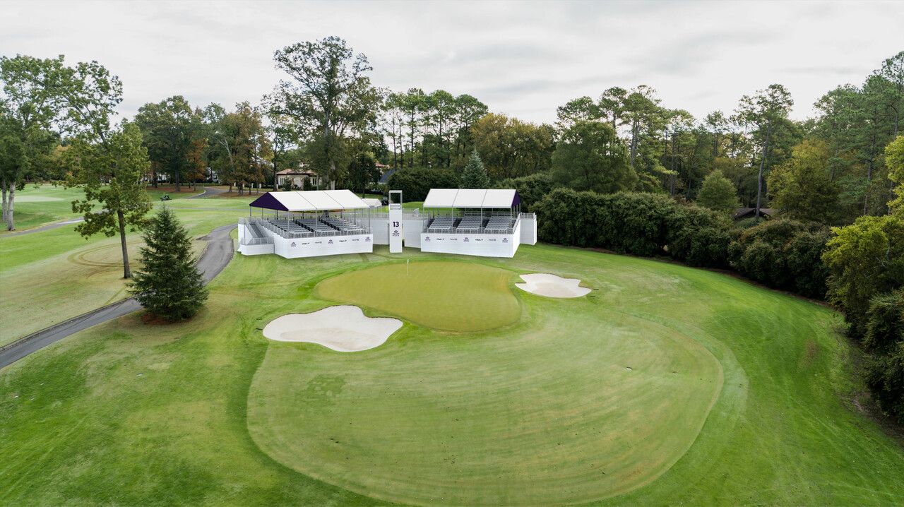 Covered stadium seating around a golf green.