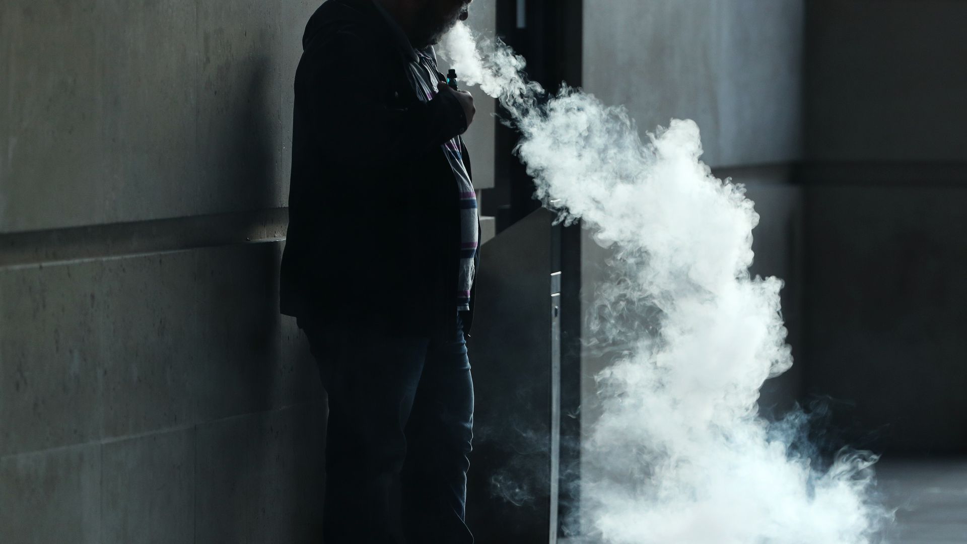 A person blowing smoke from an e-cigarette.