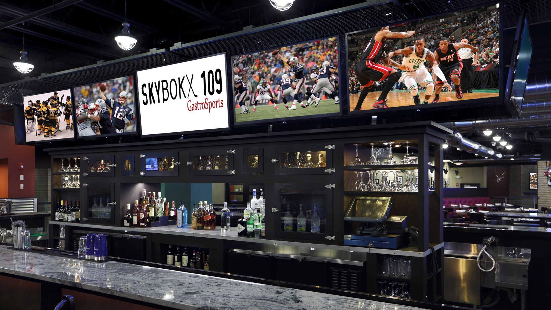 SKYBOKX 109 Sports Bar & Grill in Natick has the game on its 24 TVs. The view from the counter shows a row of five monitors above the bar.
