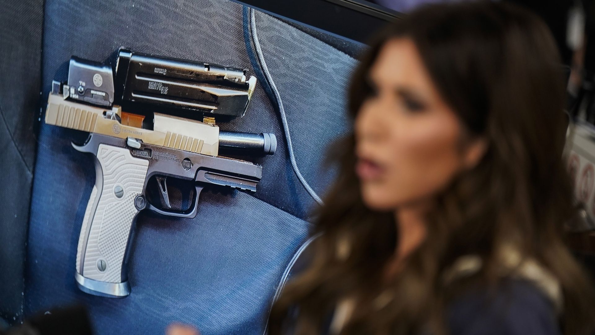Homeland Security Secretary Kristi Noem at FEMA headquarters with a display of the pistol recovered in Minneapolis behind her, where federal agents fatally shot ICU nurse Alex Pretti.