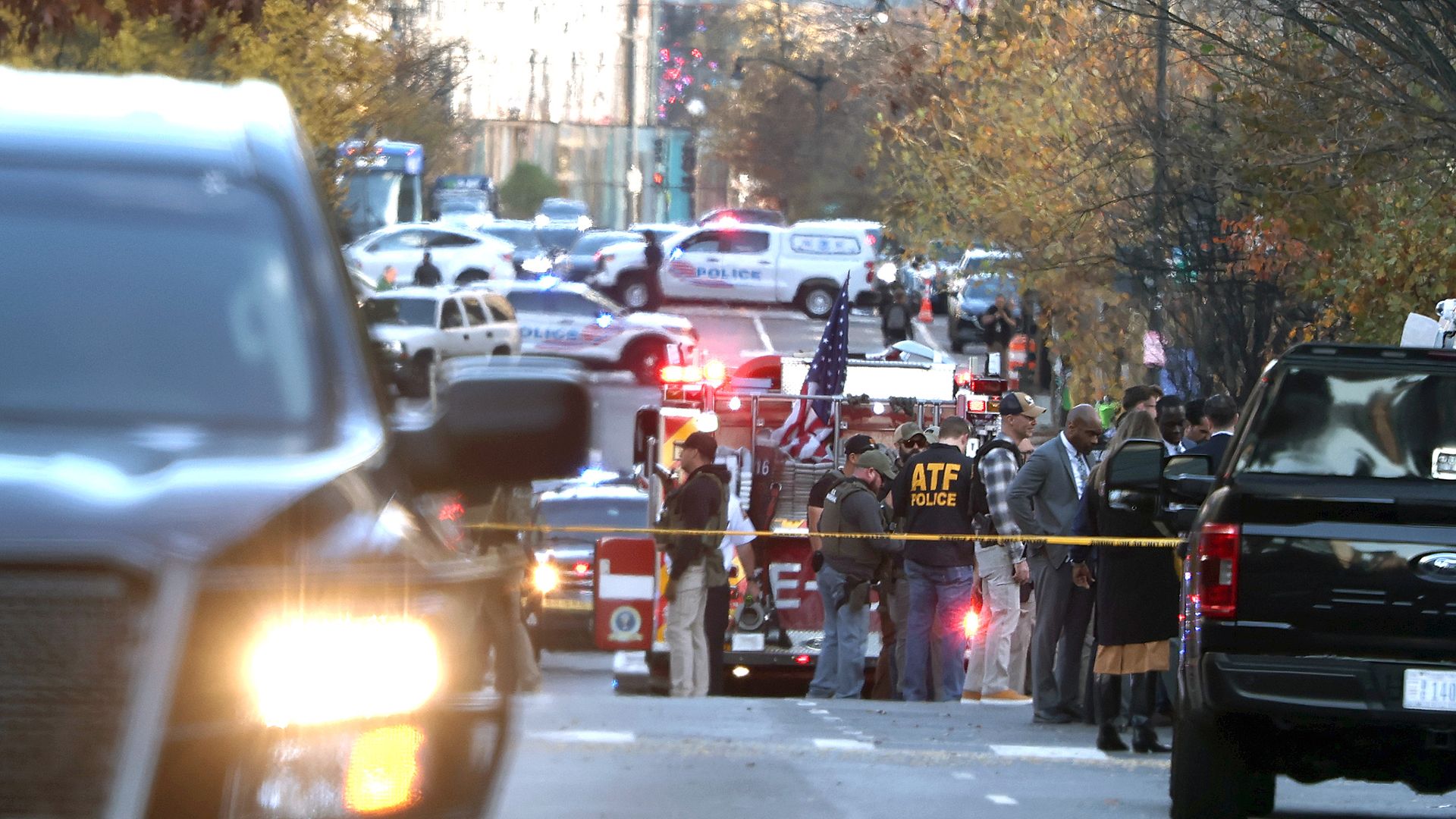Cars can be seen stopped near yellow police tape as members of law enforcement, including the U.S. Secret Service and the Washington Metropolitan Police Department, respond to a shooting near trees in Washington, D.C., on November 26, 2025 in Washington, DC. A