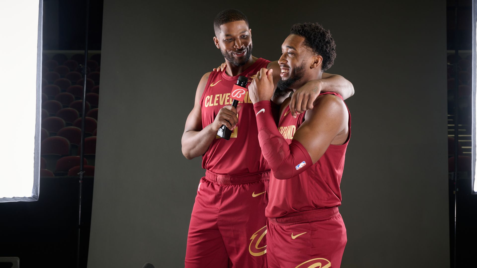 Tristan Thompson with a microphone and arm around Donovan Mitchell's shoulder during a photoshoot