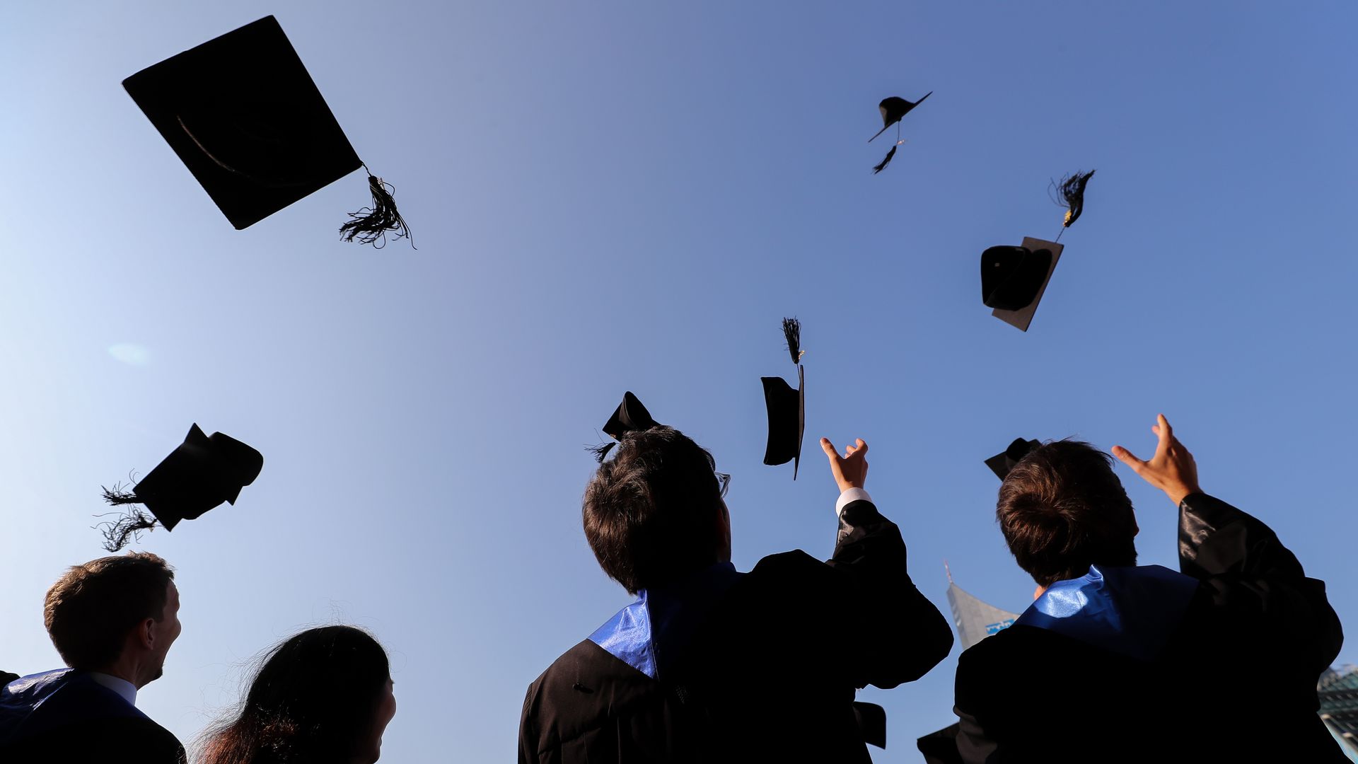 College graduates throwing caps in the air