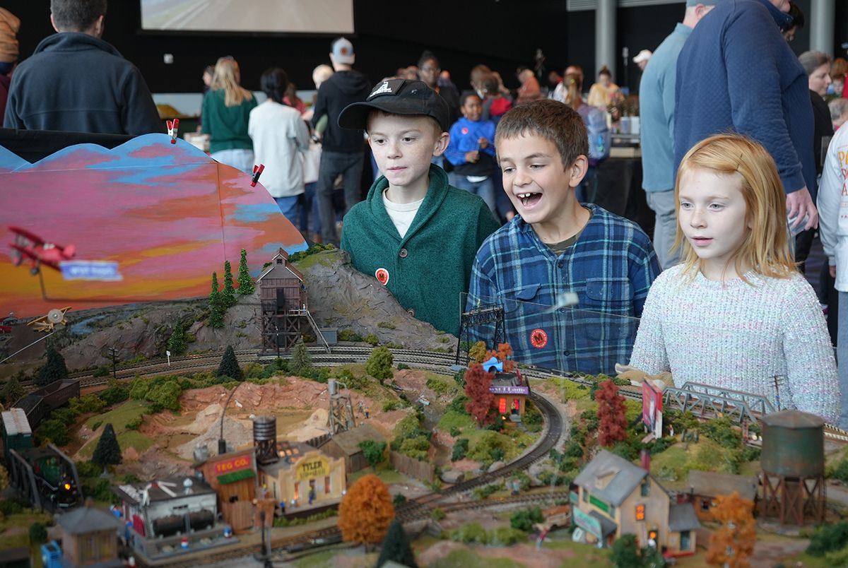 a bunch of kids looking at model trains 