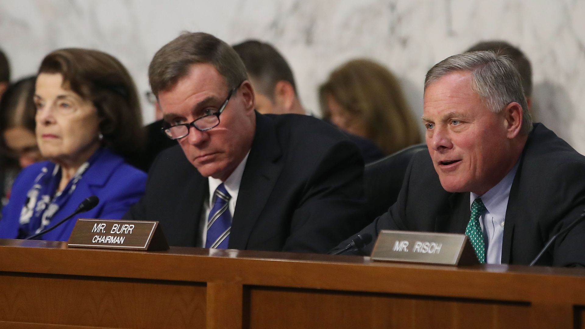 Three senators sit on a committee dais