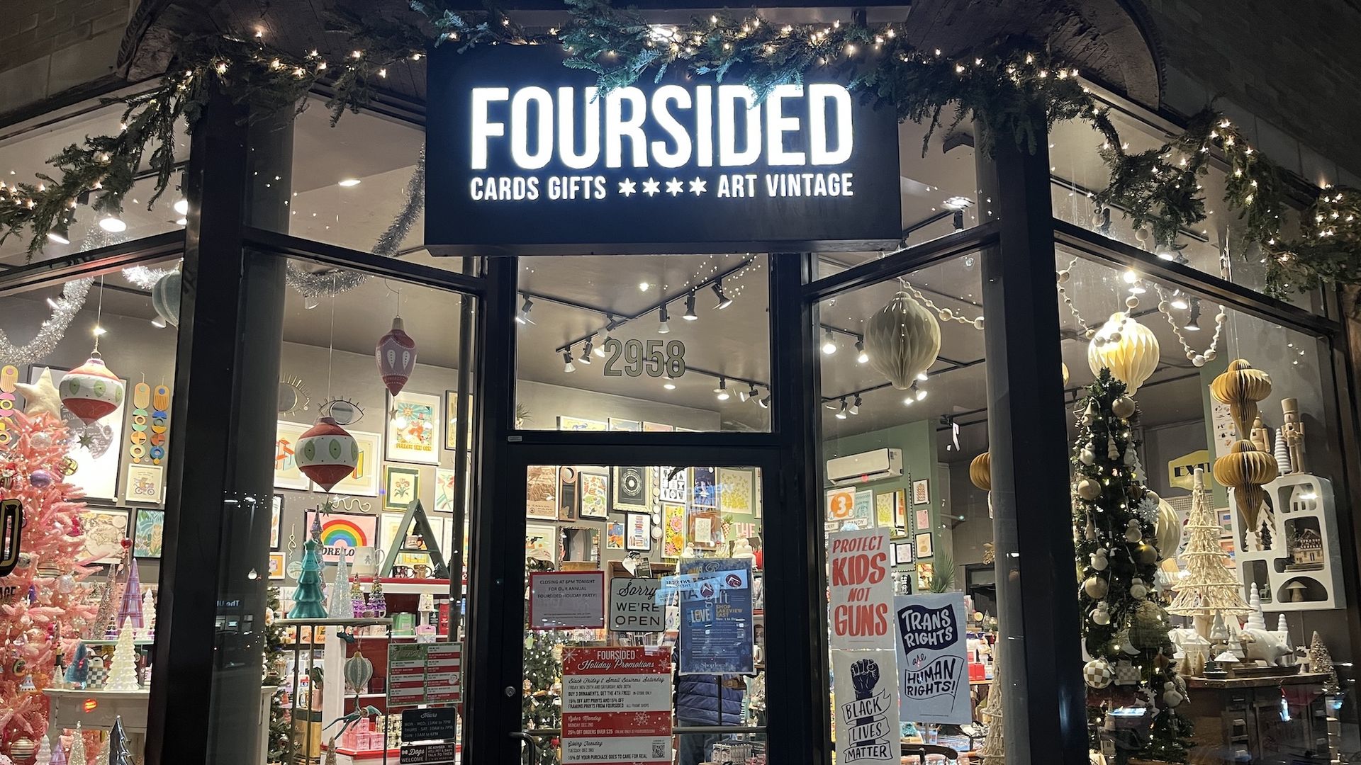 Front of a store with a sign above the door "Foursided Cards Gifts Art Vintage"