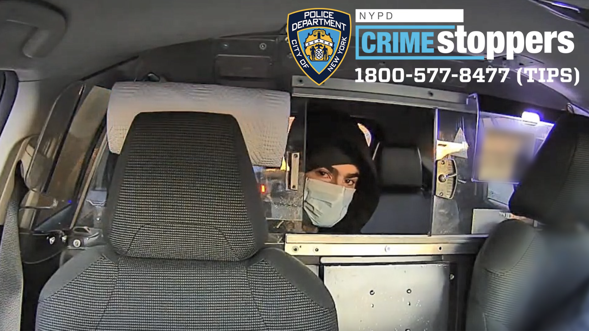 A person looking through a cab opening with a mask on and a hood