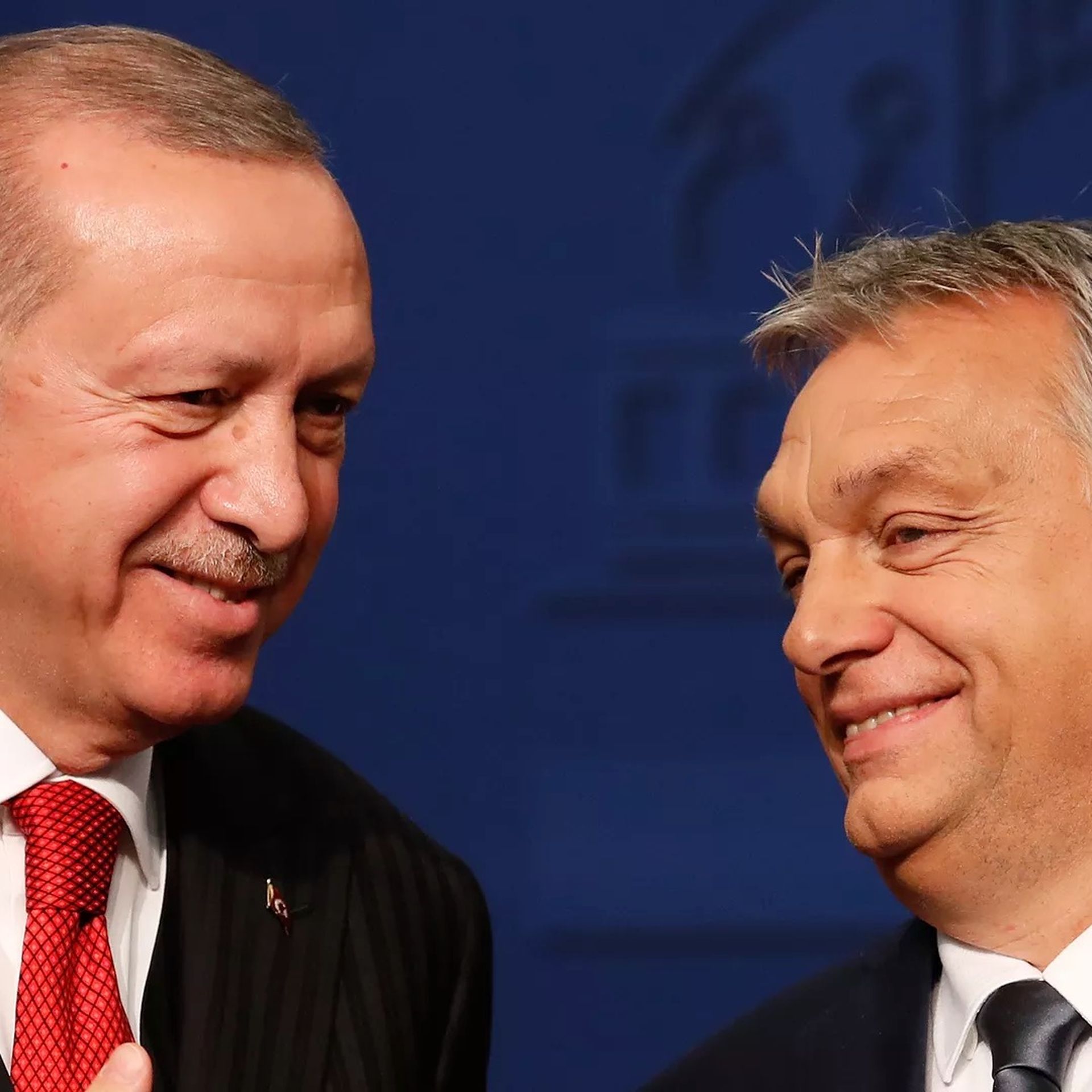 The president of Turkey and prime minister of Hungary are seen smiling together.