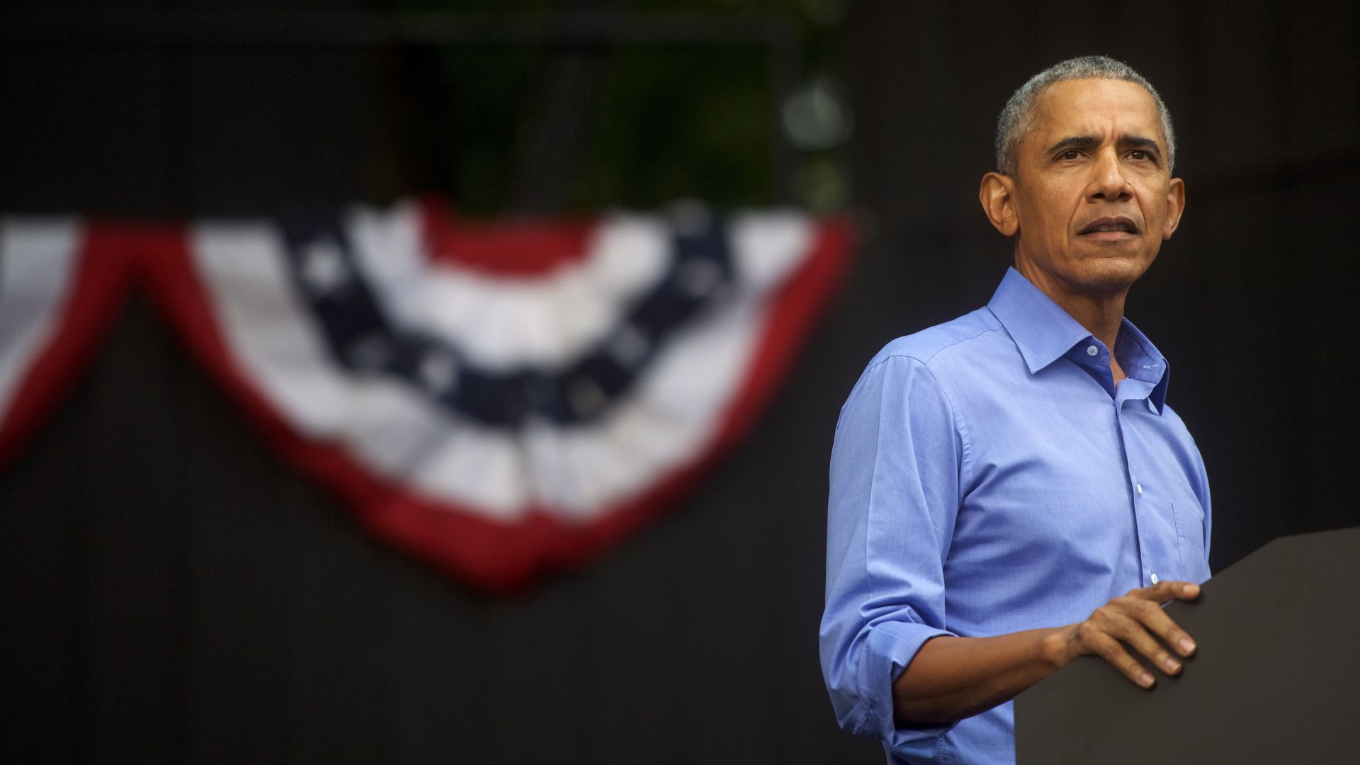 Obama grips a podium and looks worried.