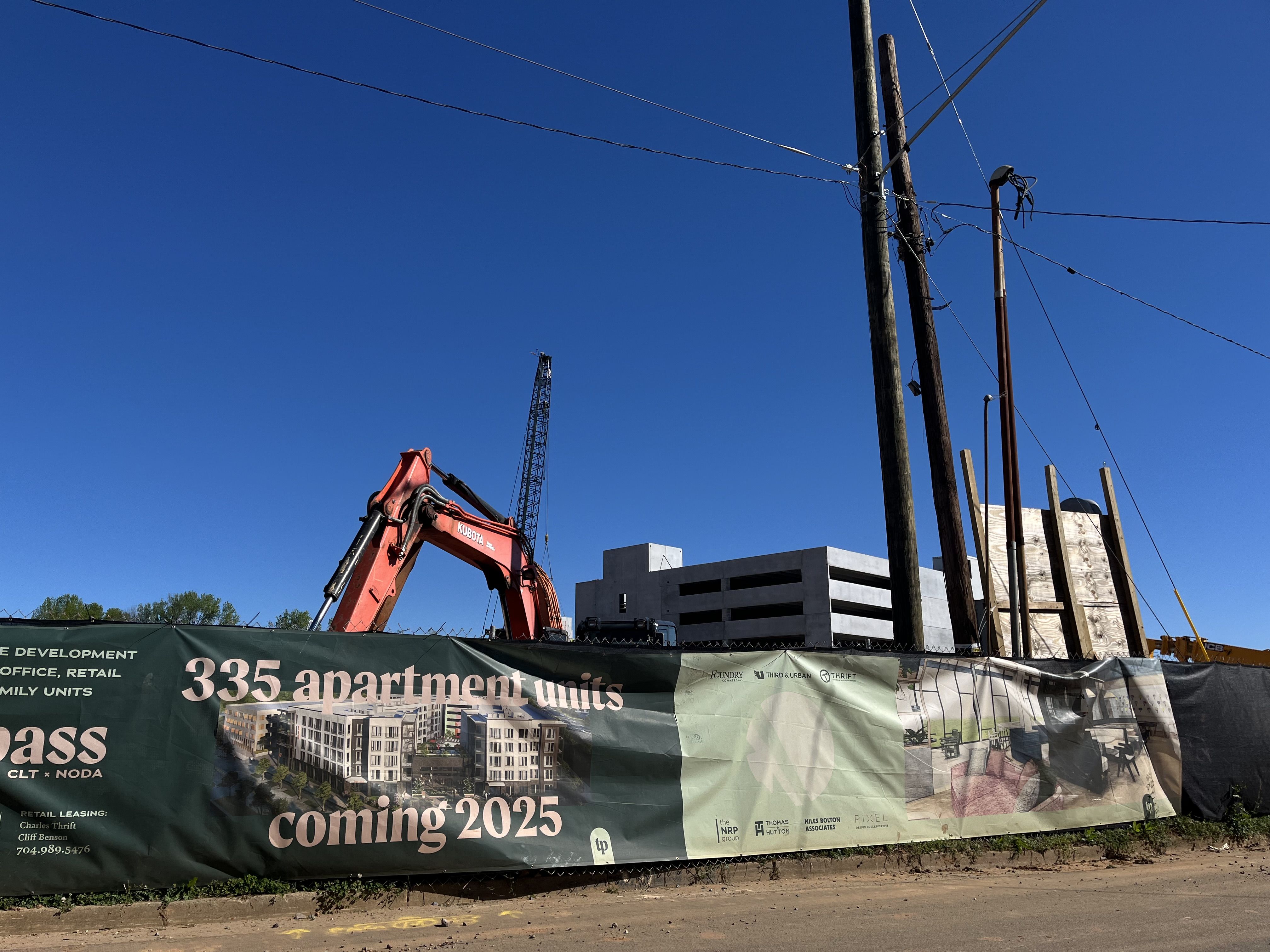 Construction site and banner announcing 335 apartment units coming 2025
